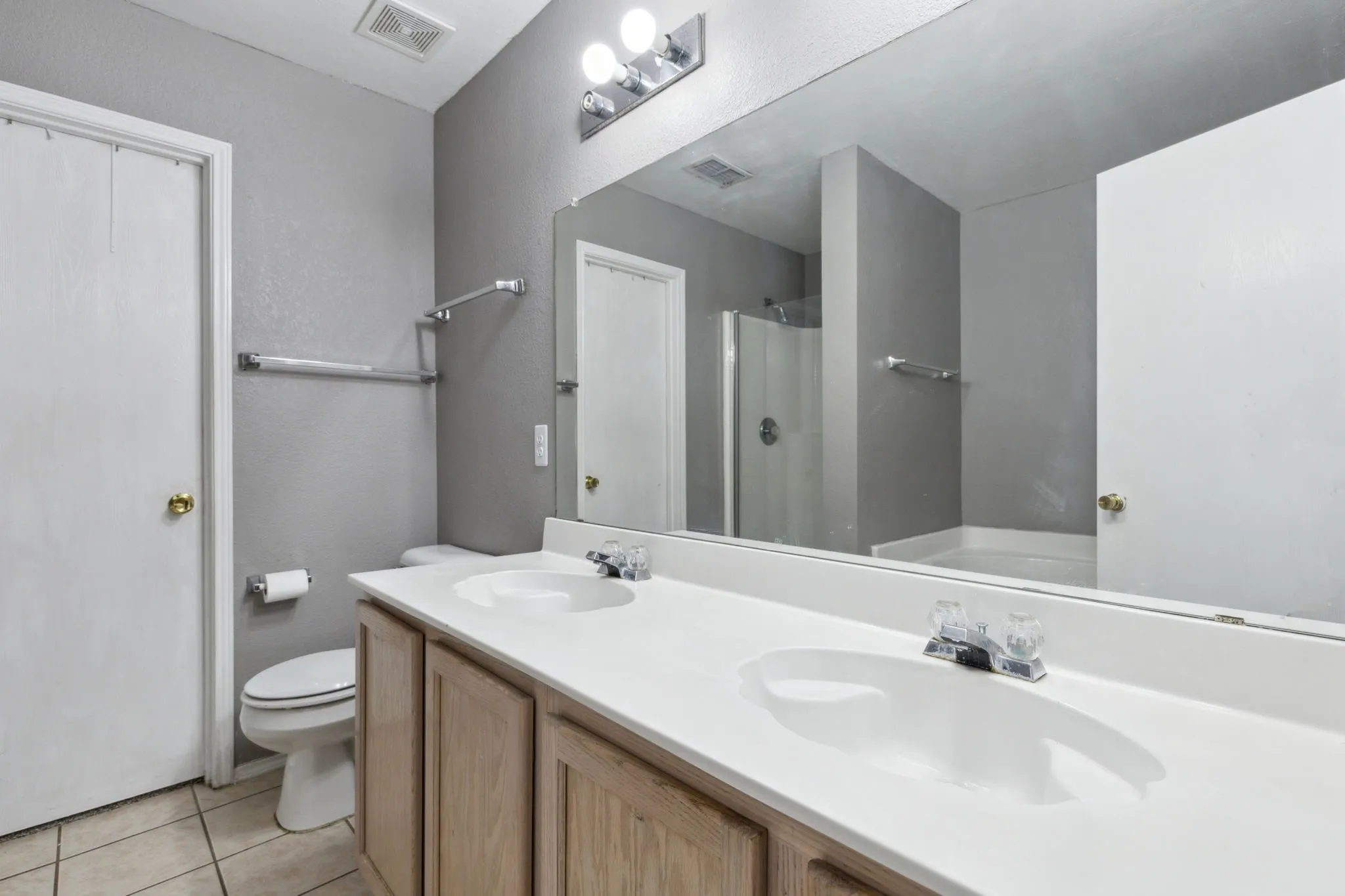 Primary Bathroom featuring dual sinks and a large walk-in closet.