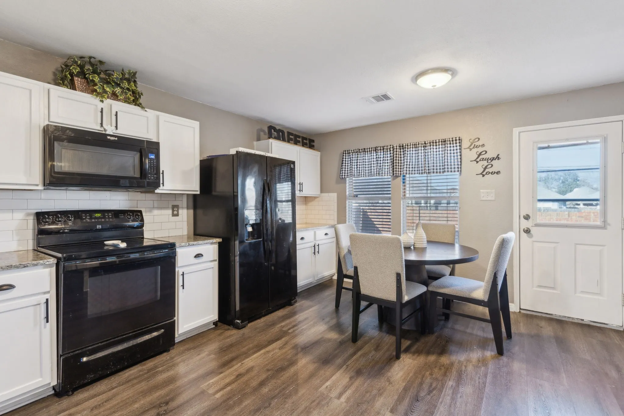 A cute breakfast nook and coffee bar, and sleek black appliances.