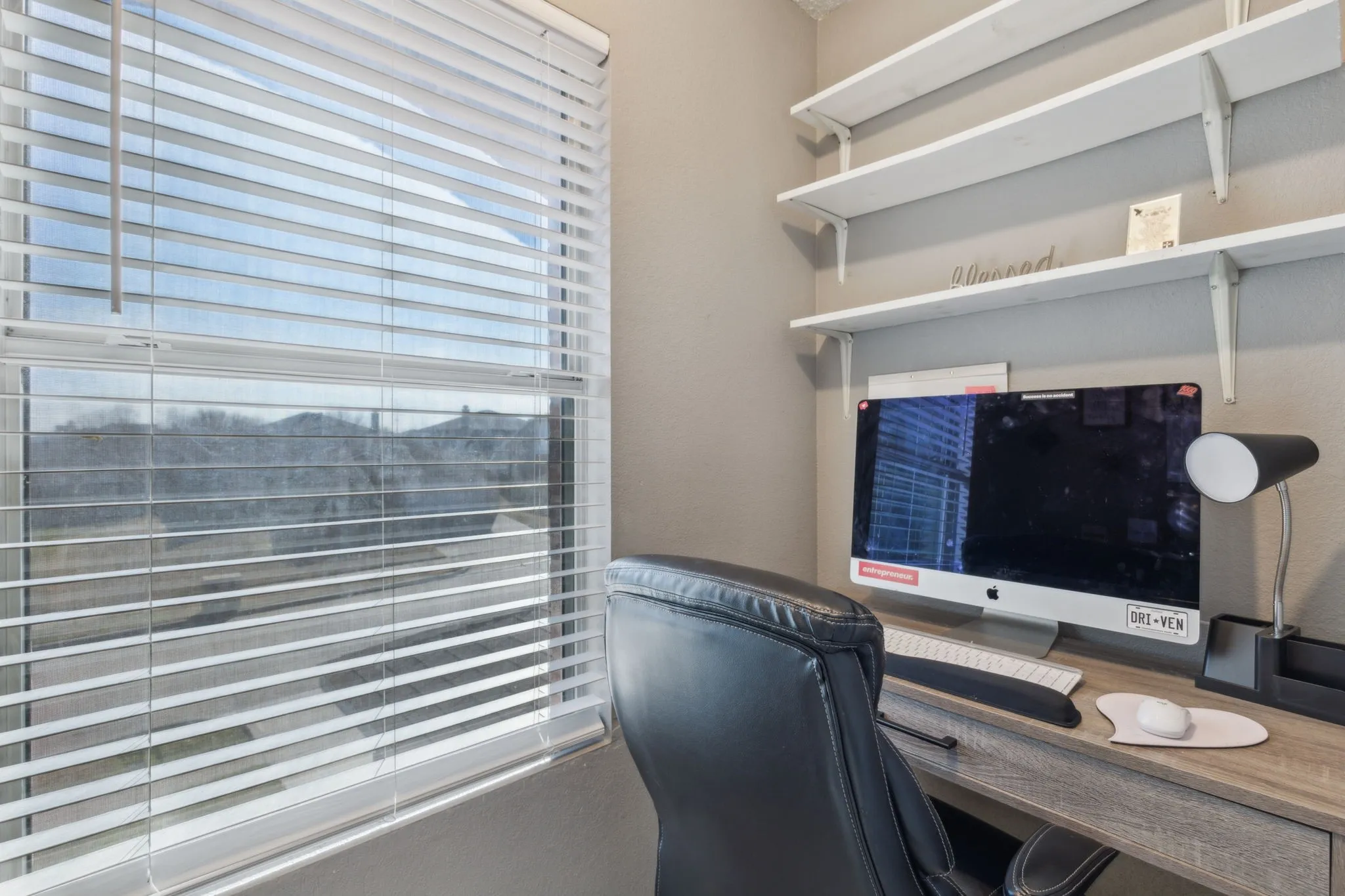 Check out this functional office nook, equipped with a desk and shelving.