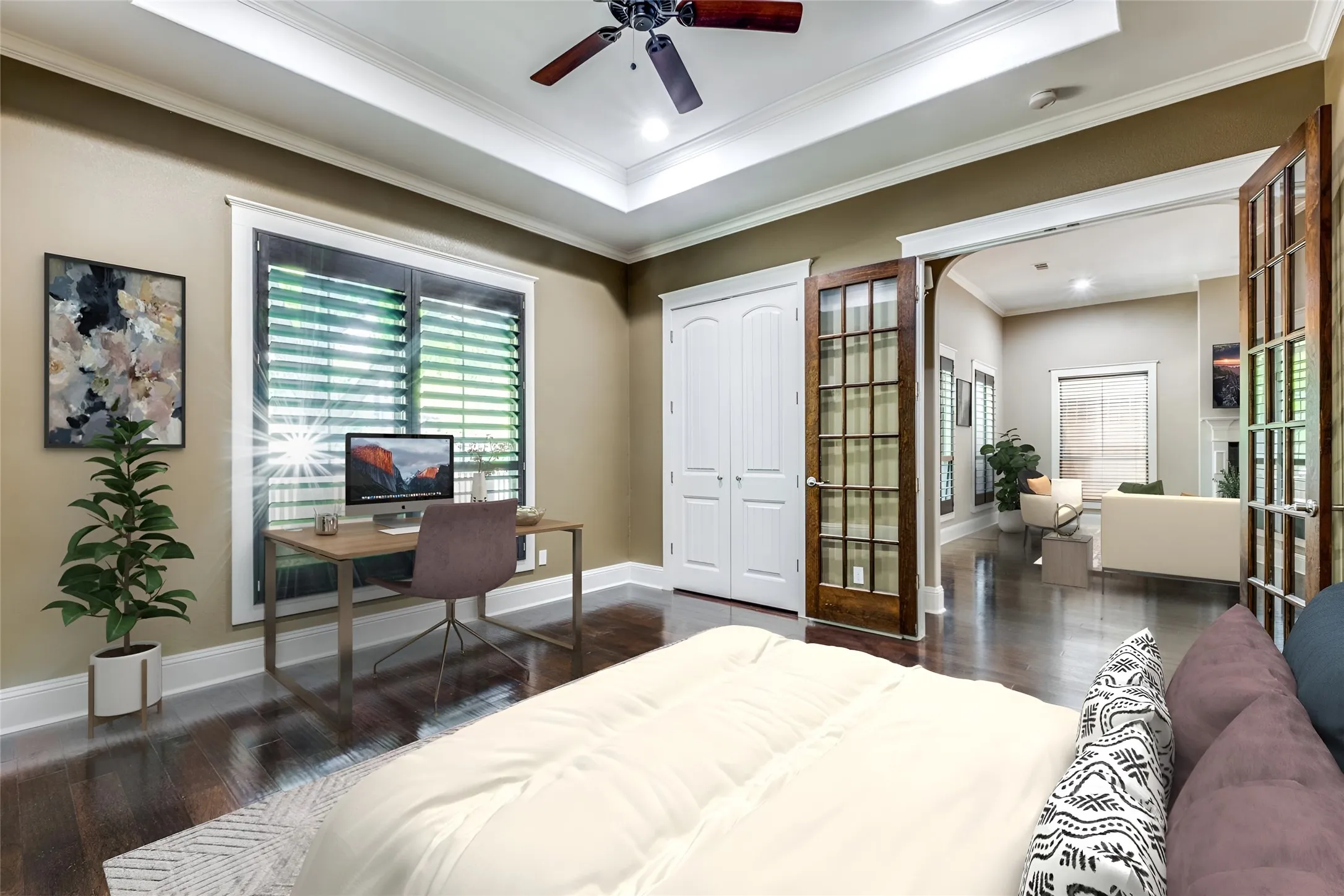 Interior space featuring dark wood-finish flooring, white tray ceiling, and a ceiling fan with wood-finish blades