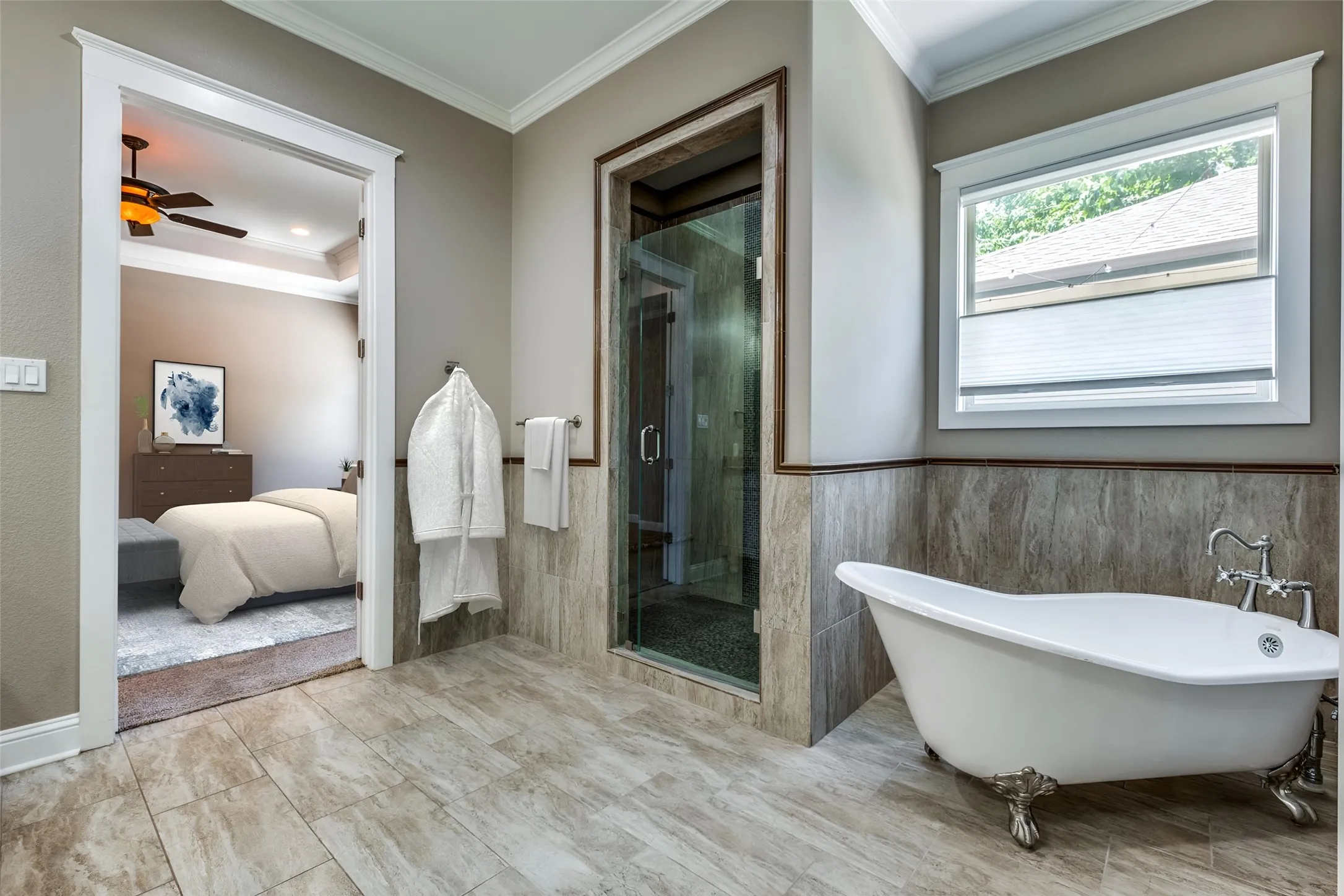 Bathroom featuring a freestanding clawfoot tub, glass-enclosed shower, wood-look tile flooring, and wall-mounted towel racks
