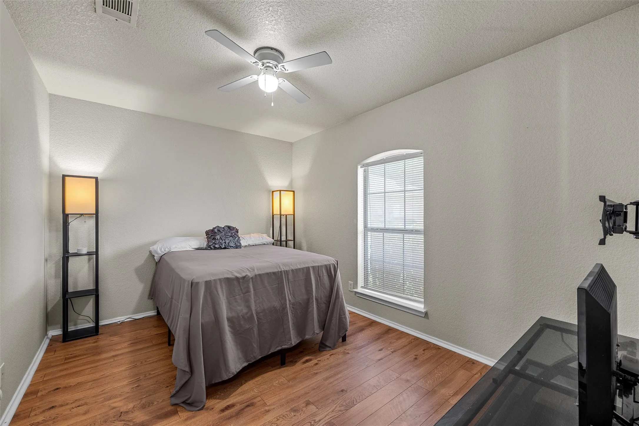 Warm wood-finish flooring complements the neutral wall tones
