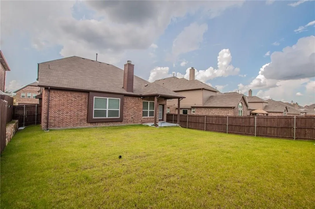 Expansive green lawn with a full privacy fence