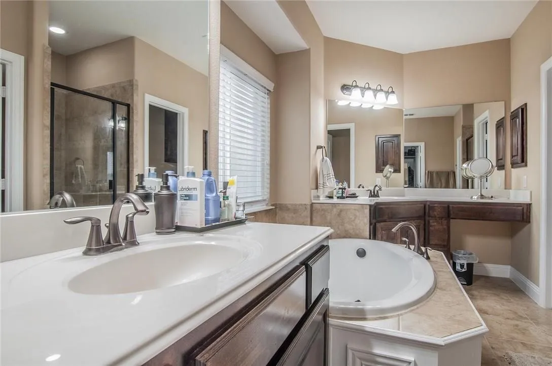 Dual vanity with integrated sinks, brushed nickel fixtures, and dark wood-finish cabinetry