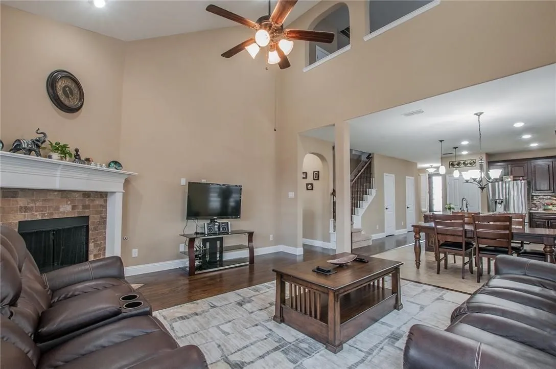Spacious living area featuring a vaulted ceiling and a ceiling fan with integrated lighting