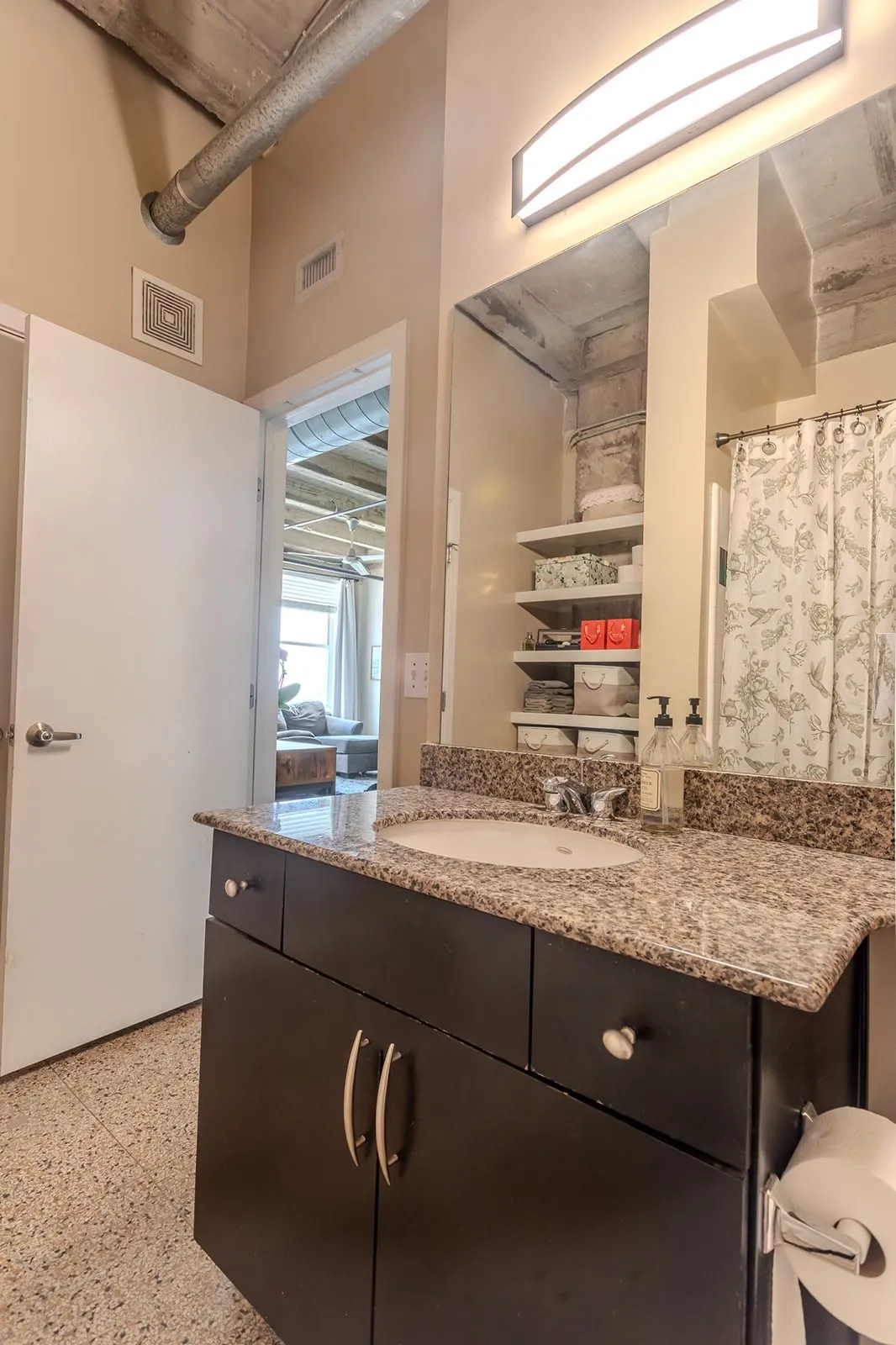 Bathroom vanity with a granite-style countertop, undermount sink, and dark wood cabinetry