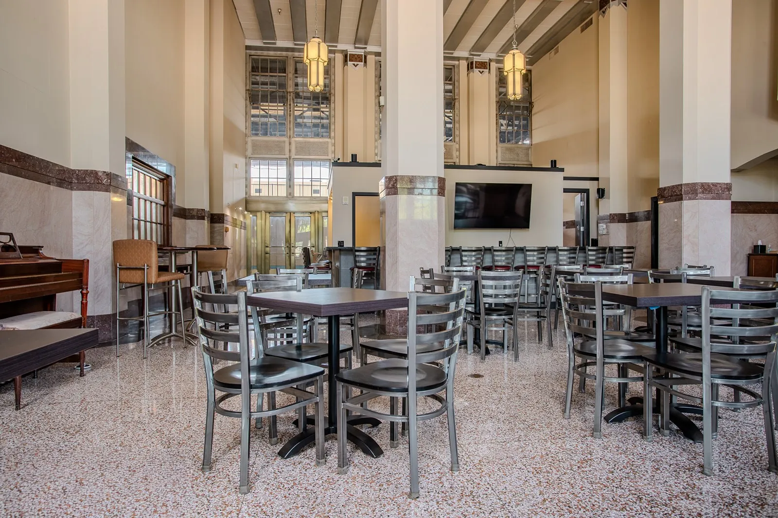 Spacious interior featuring high ceilings, terrazzo flooring, and decorative wall paneling