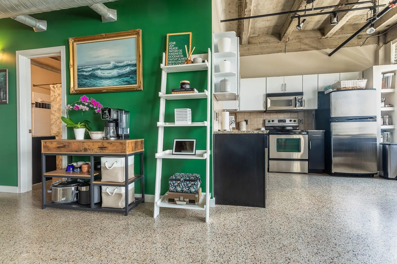 Kitchen featuring stainless steel appliances, white cabinetry, dark countertops, and tile backsplash