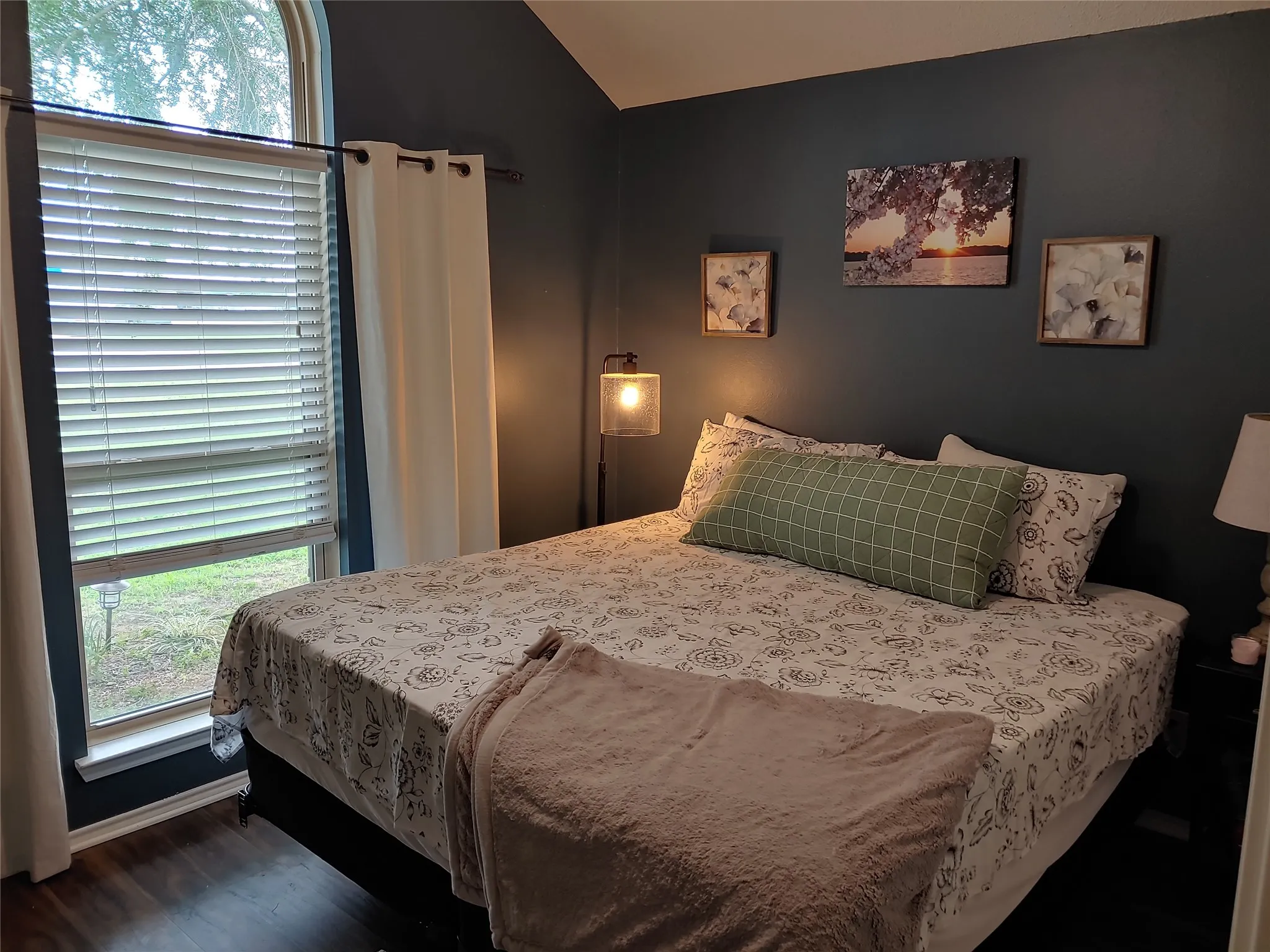 Arched window with horizontal blinds and white drapes