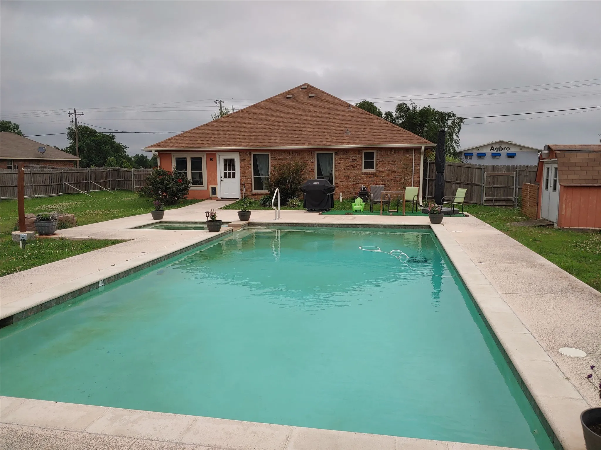 In-ground swimming pool with surrounding concrete decking