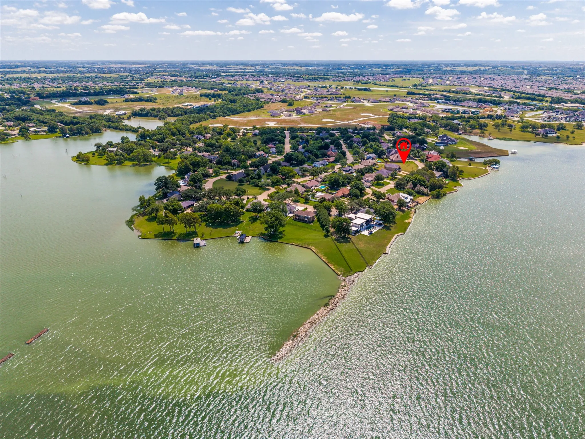 Waterfront property featuring extensive shoreline, mature trees, and residential landscaping