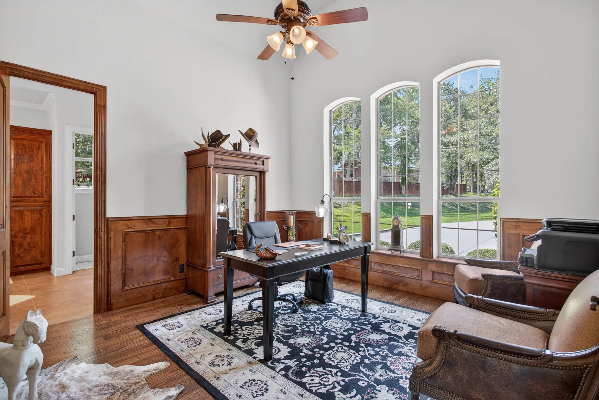 Home office is just off the entry. This room is bathed in natural light and has gorgeous wood wainscoating and wood floors.