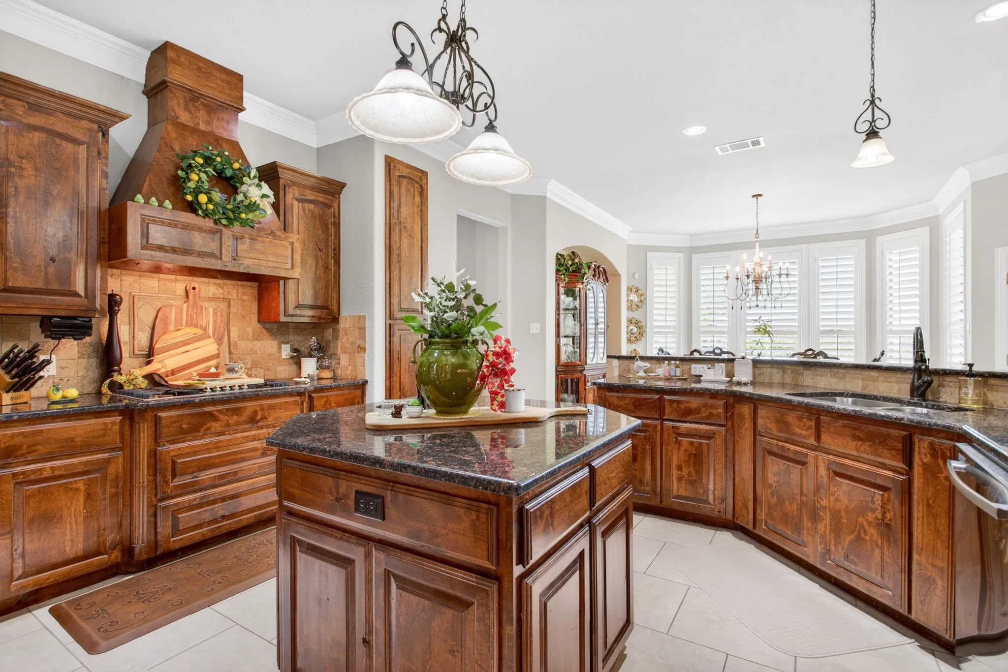 Large kitchen with tile floors and decorative lighting.
