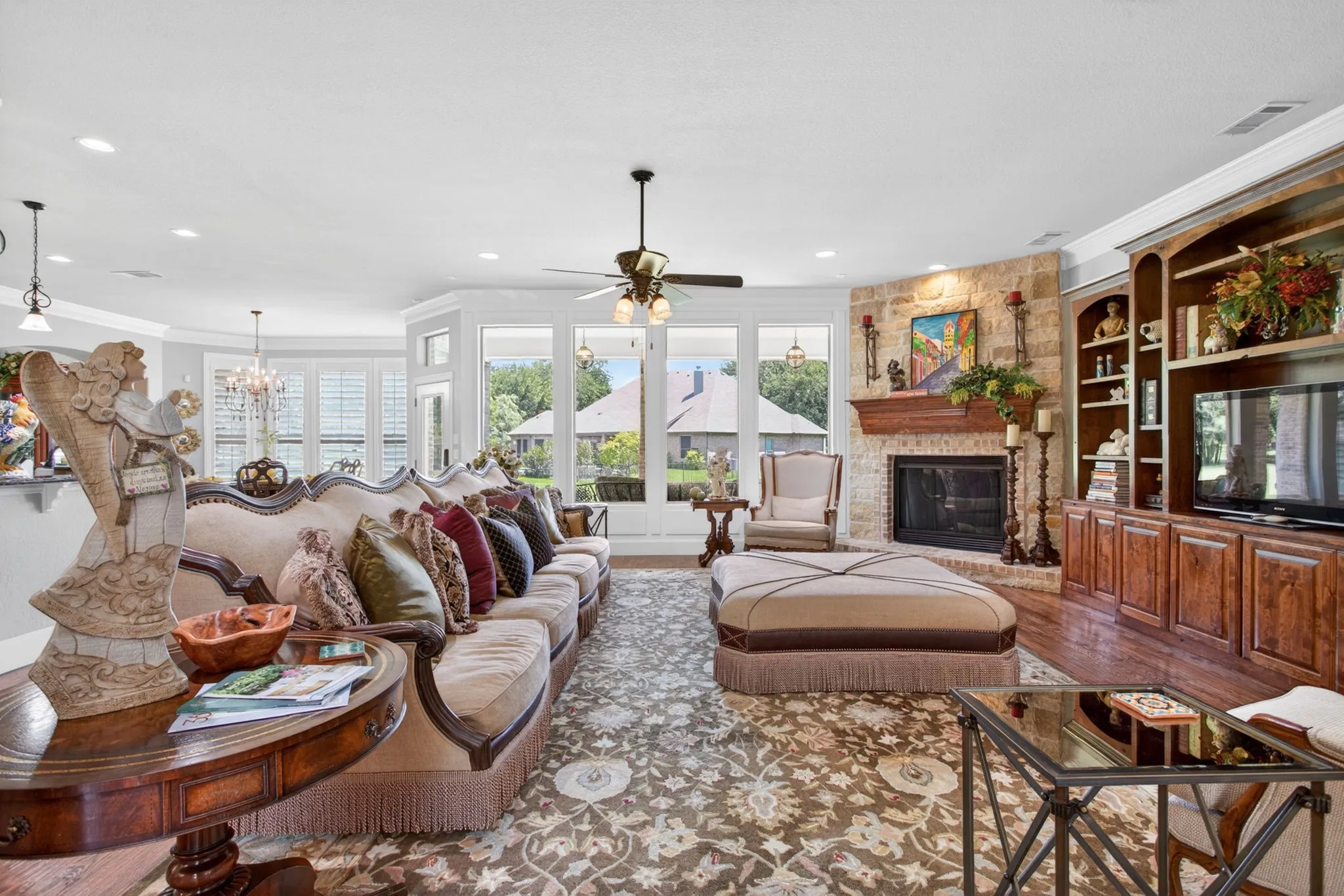 Large living room has beautiful built in bookcases and a stone fireplace
