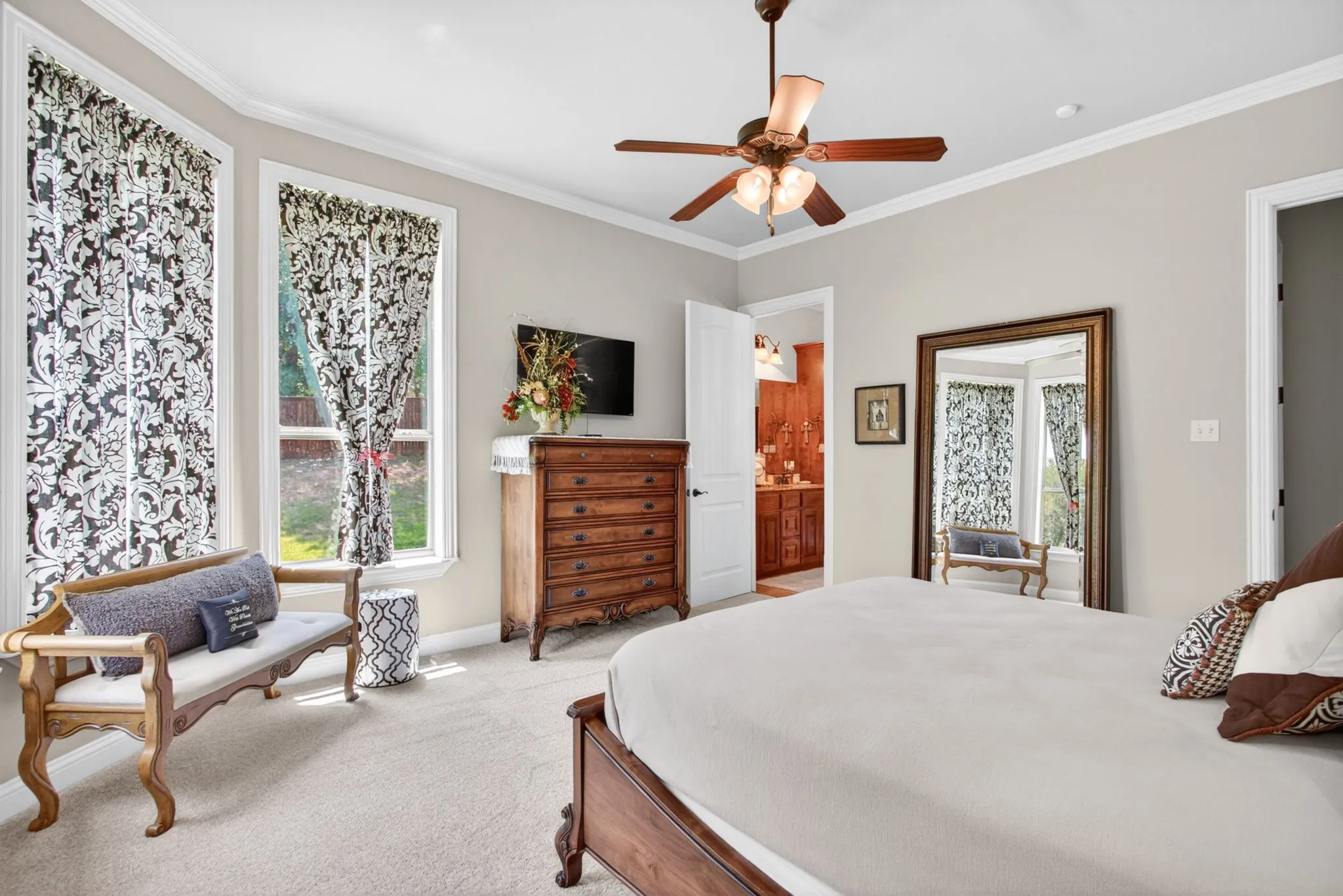 This downstairs bedroom functions as a second primary suite.