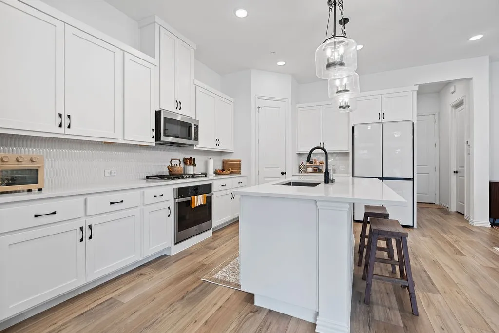 Contemporary kitchen featuring white cabinetry, light wood-finish flooring, and recessed lighting