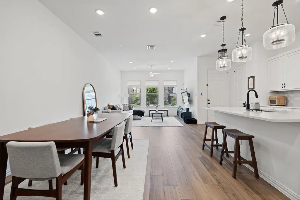 Open-concept living space featuring wood-finish flooring, recessed lighting, and multiple windows