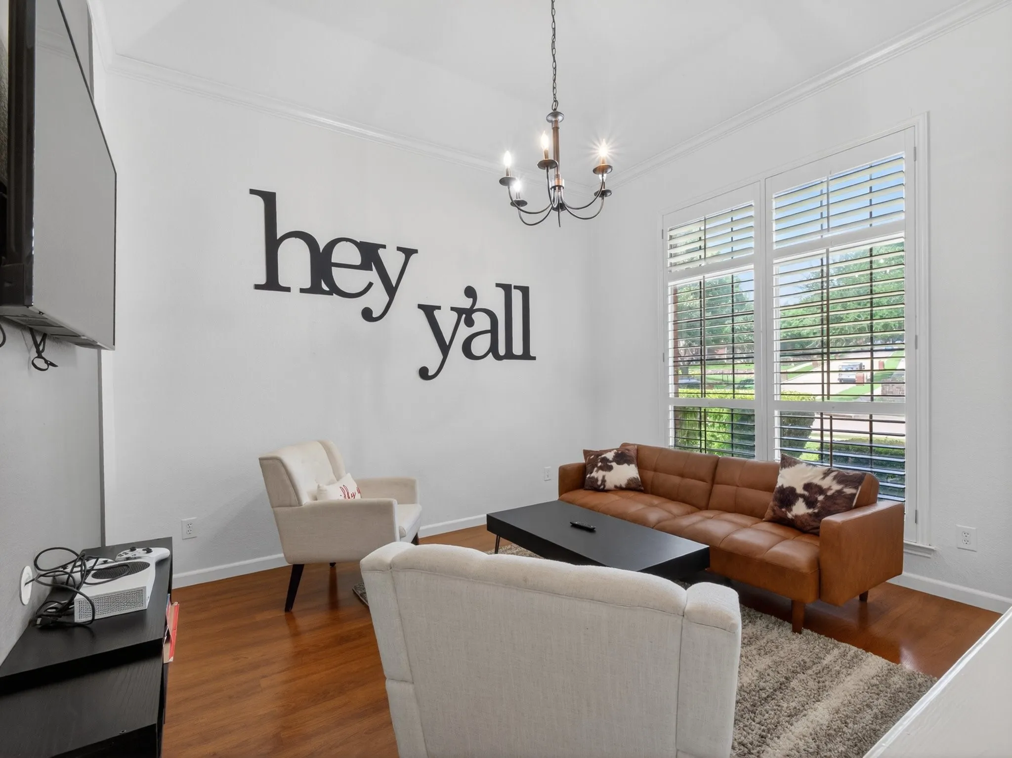 Bright room featuring wood-finish flooring, white walls, and crown molding