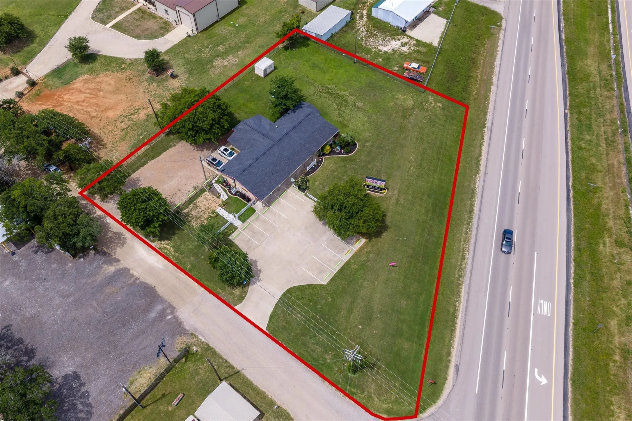 Aerial perspective of a commercial property featuring a brick building with a dark roof