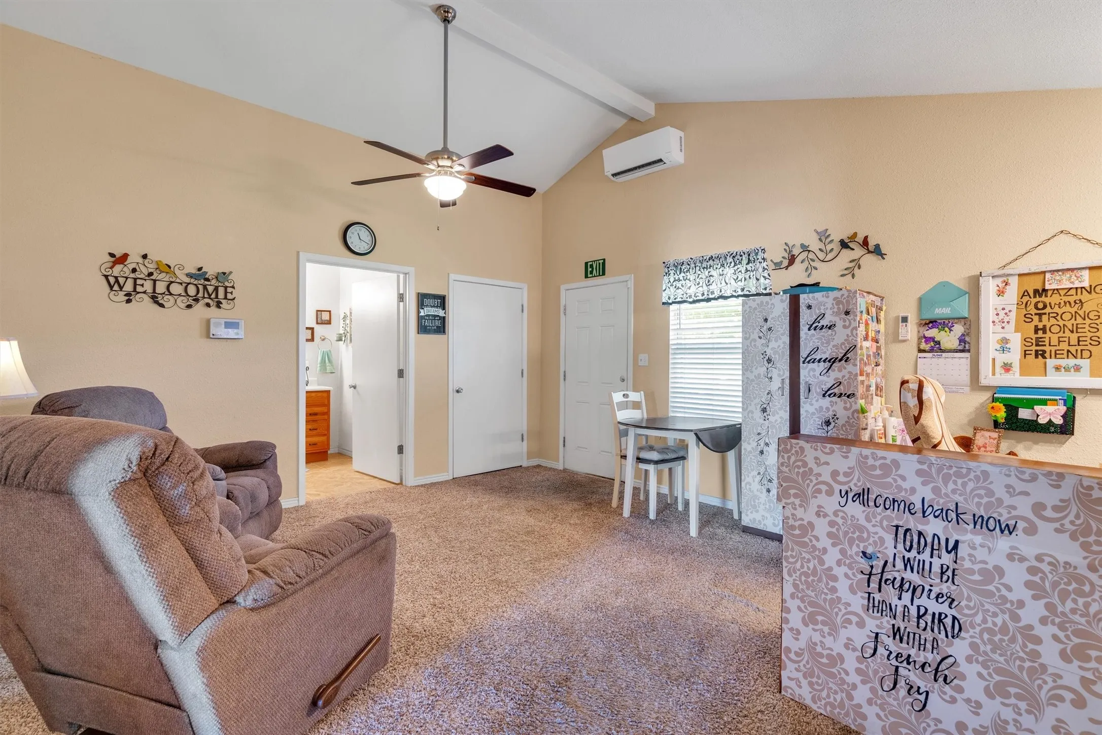 Vaulted ceiling with exposed beam, featuring a ceiling fan with integrated lighting