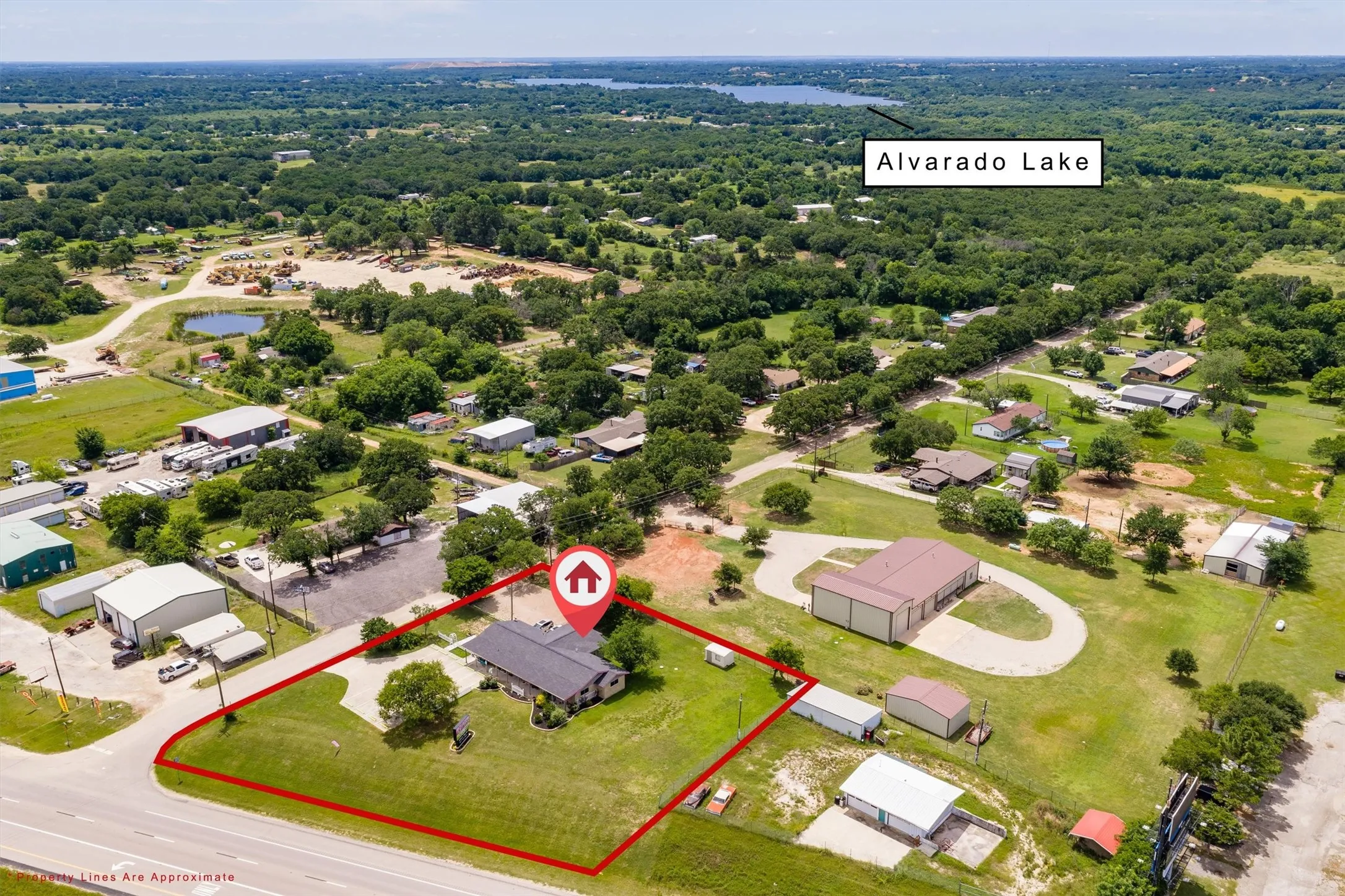 Expansive corner lot featuring a single-story residence with a dark roof and mature trees