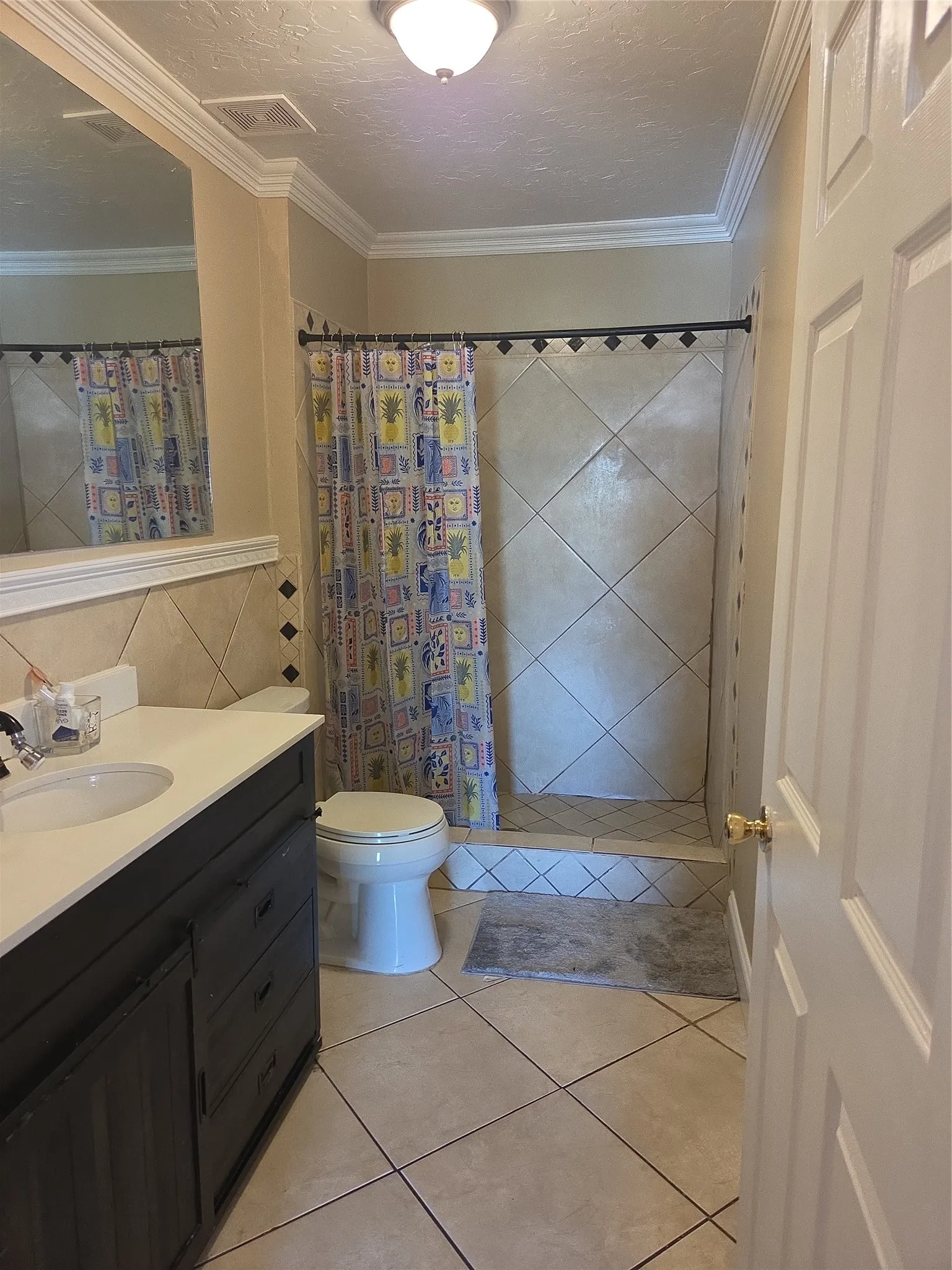 Tile flooring throughout with a walk-in shower featuring diagonal tile work