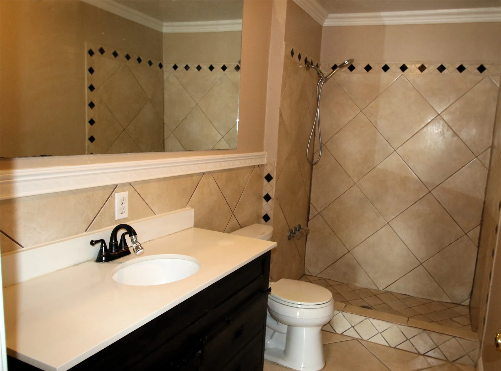 Vanity with white countertop, undermount sink, and dark cabinetry