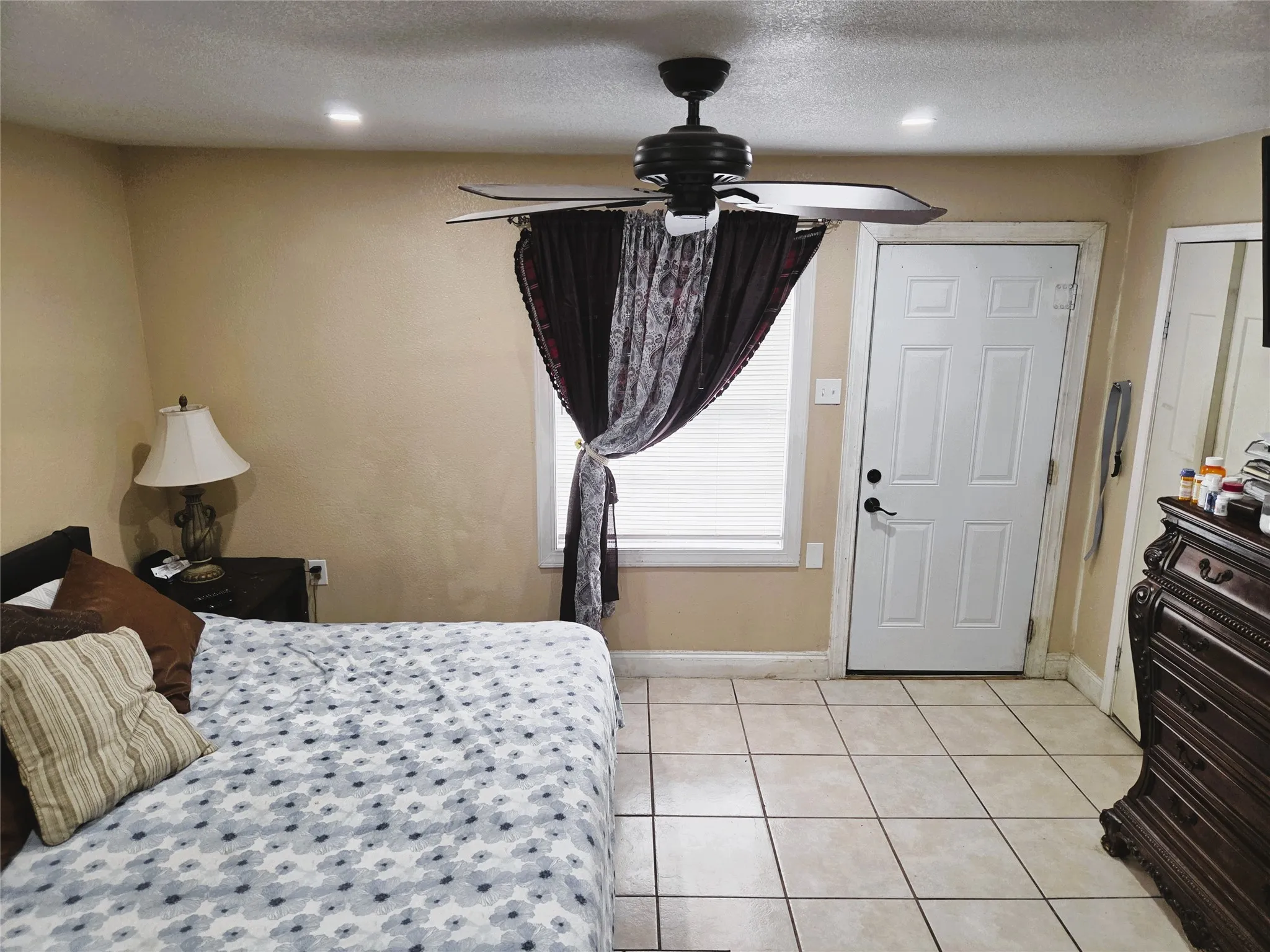 Room with light-toned wall paint and square tile flooring