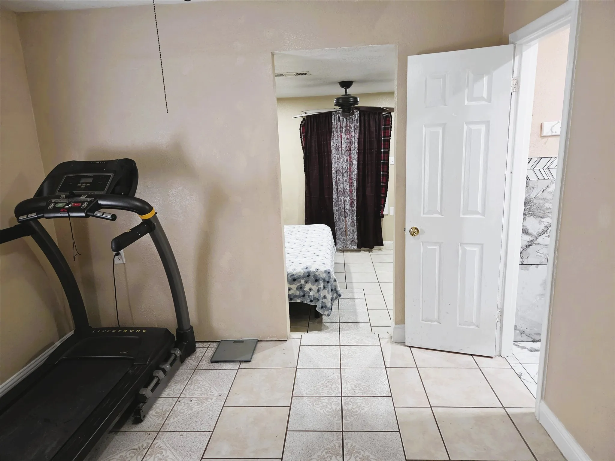 Neutral-toned tile flooring present throughout the space