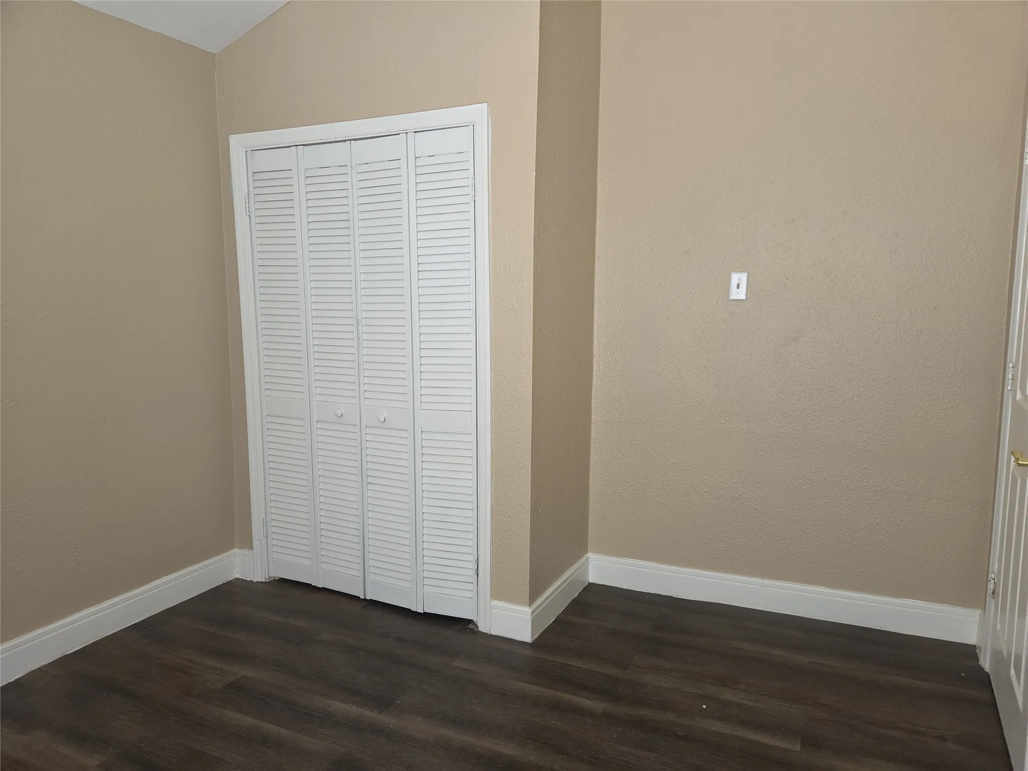 Wood-finish flooring with white baseboards, complemented by light beige wall paint
