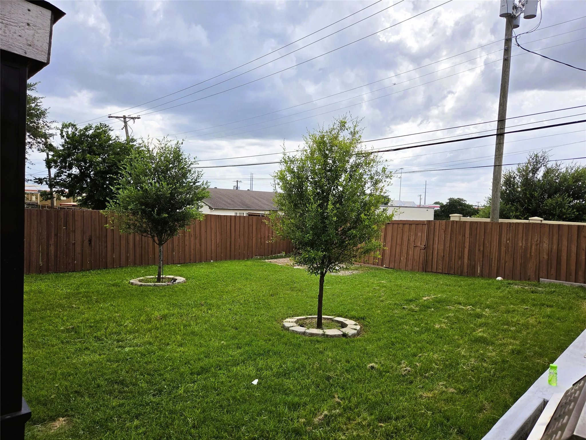 Expansive grassy yard featuring a new privacy fence
