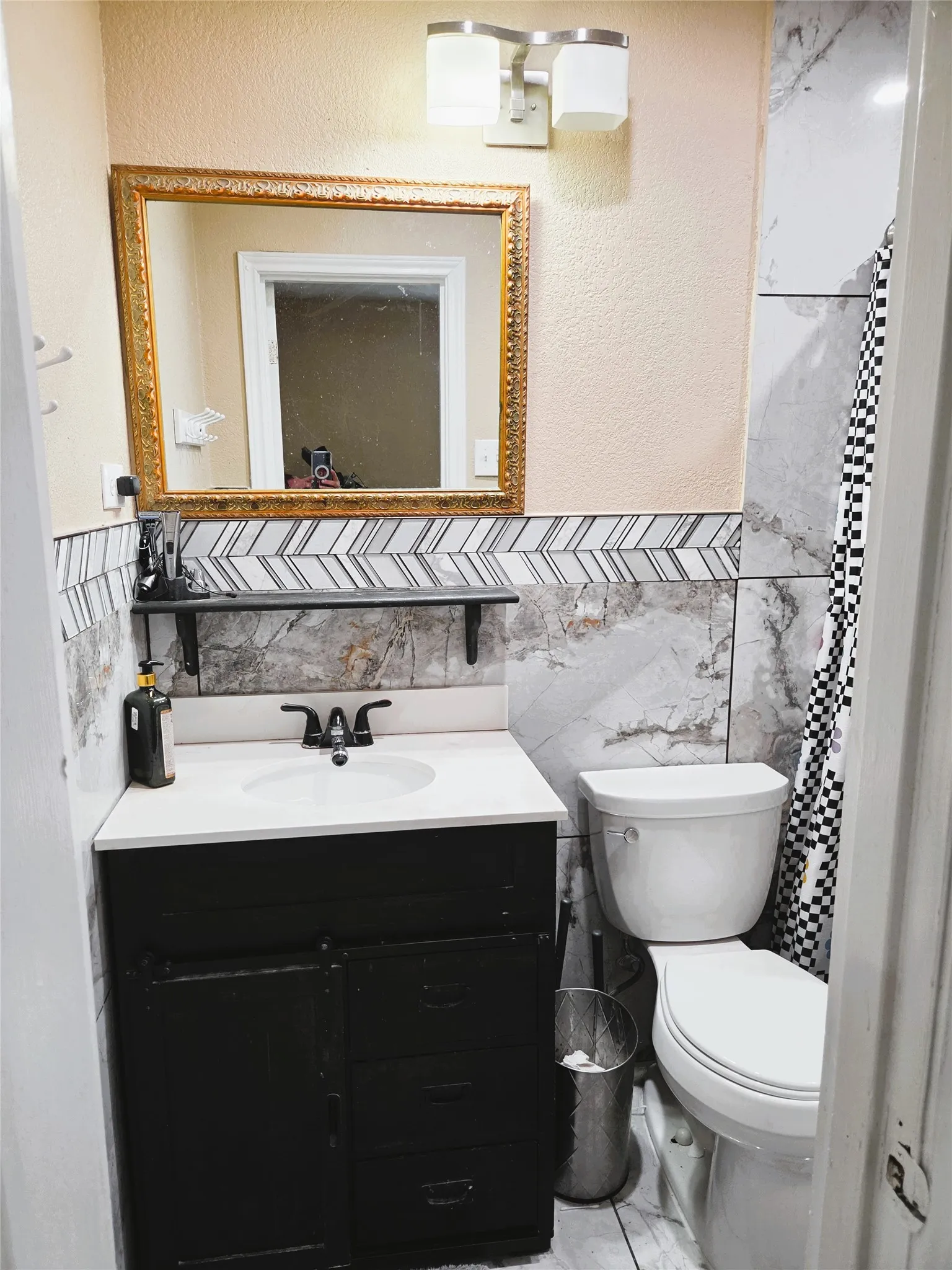 Bathroom vanity featuring a white countertop, black cabinetry, and a modern black faucet