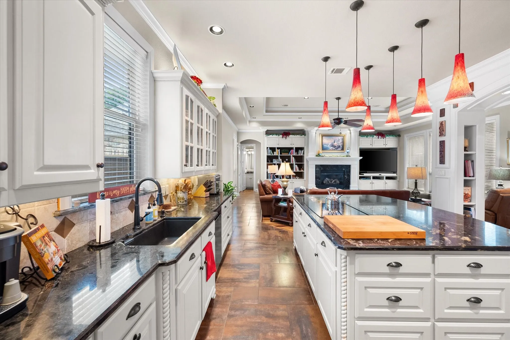 White cabinetry with dark hardware, a dark countertop, and a tiled backsplash