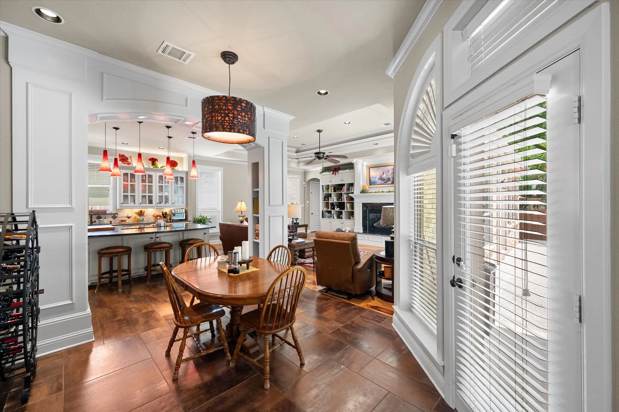 Spacious dining area featuring wood-finish flooring, a decorative chandelier, and an arched entryway to the kitchen