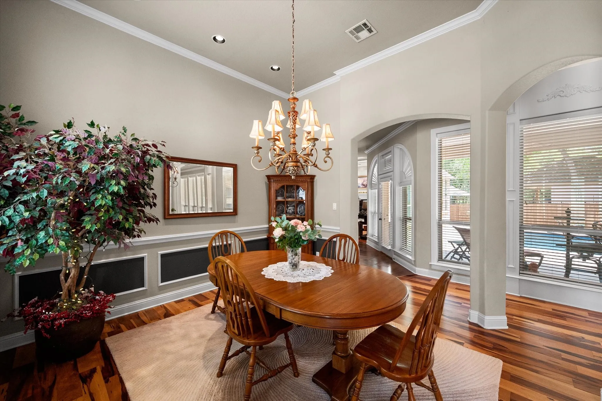 Formal dining room featuring hardwood flooring, crown molding, and a chandelier light fixture