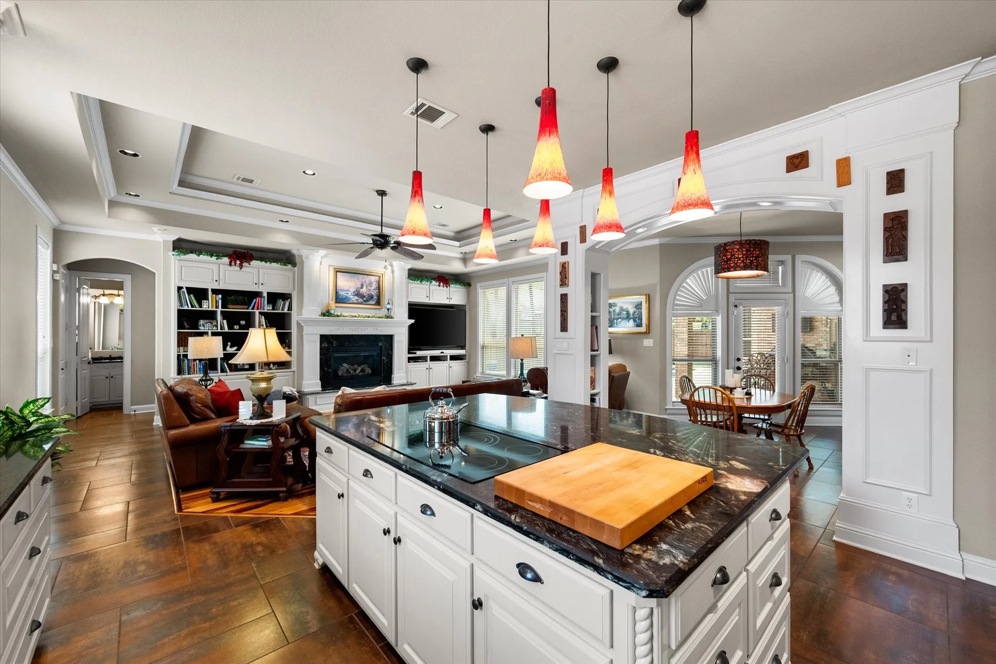 Kitchen island with a dark polished countertop and white cabinetry