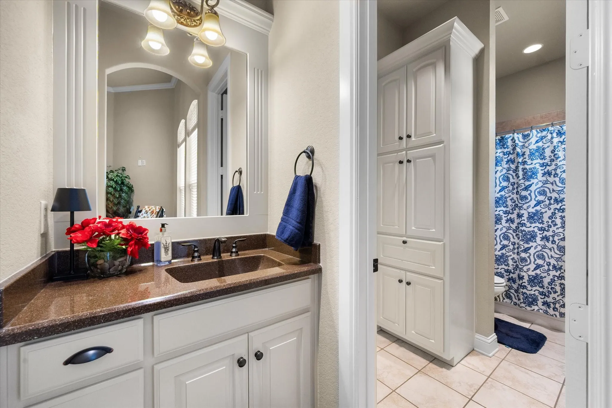 Bathroom featuring a white vanity, brown countertop, and a built-in storage cabinet