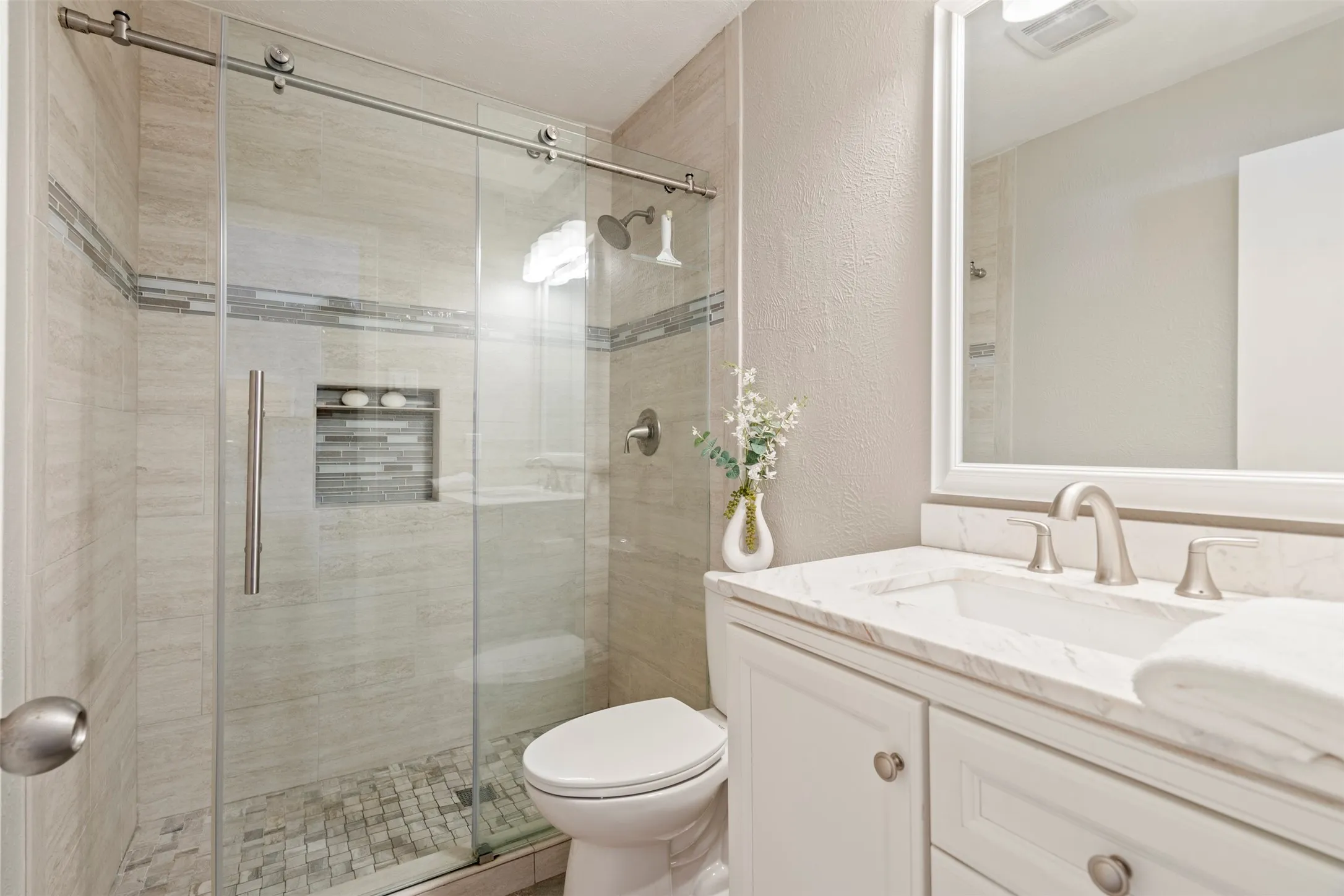 Primary Ensuite with gorgeous spa like finishes for shower, vanity, and flooring.
