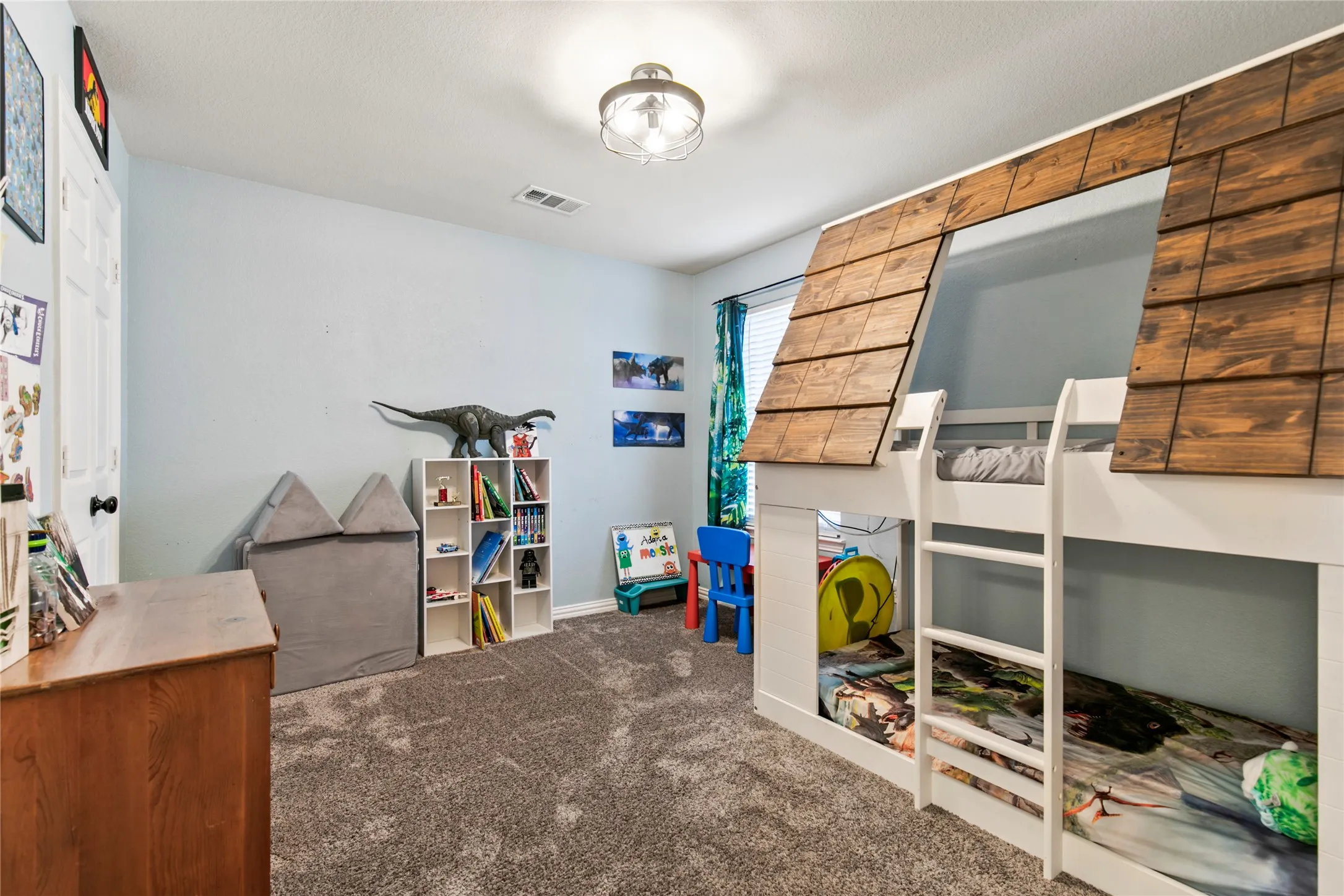 Bright room featuring light blue walls and plush grey carpeting