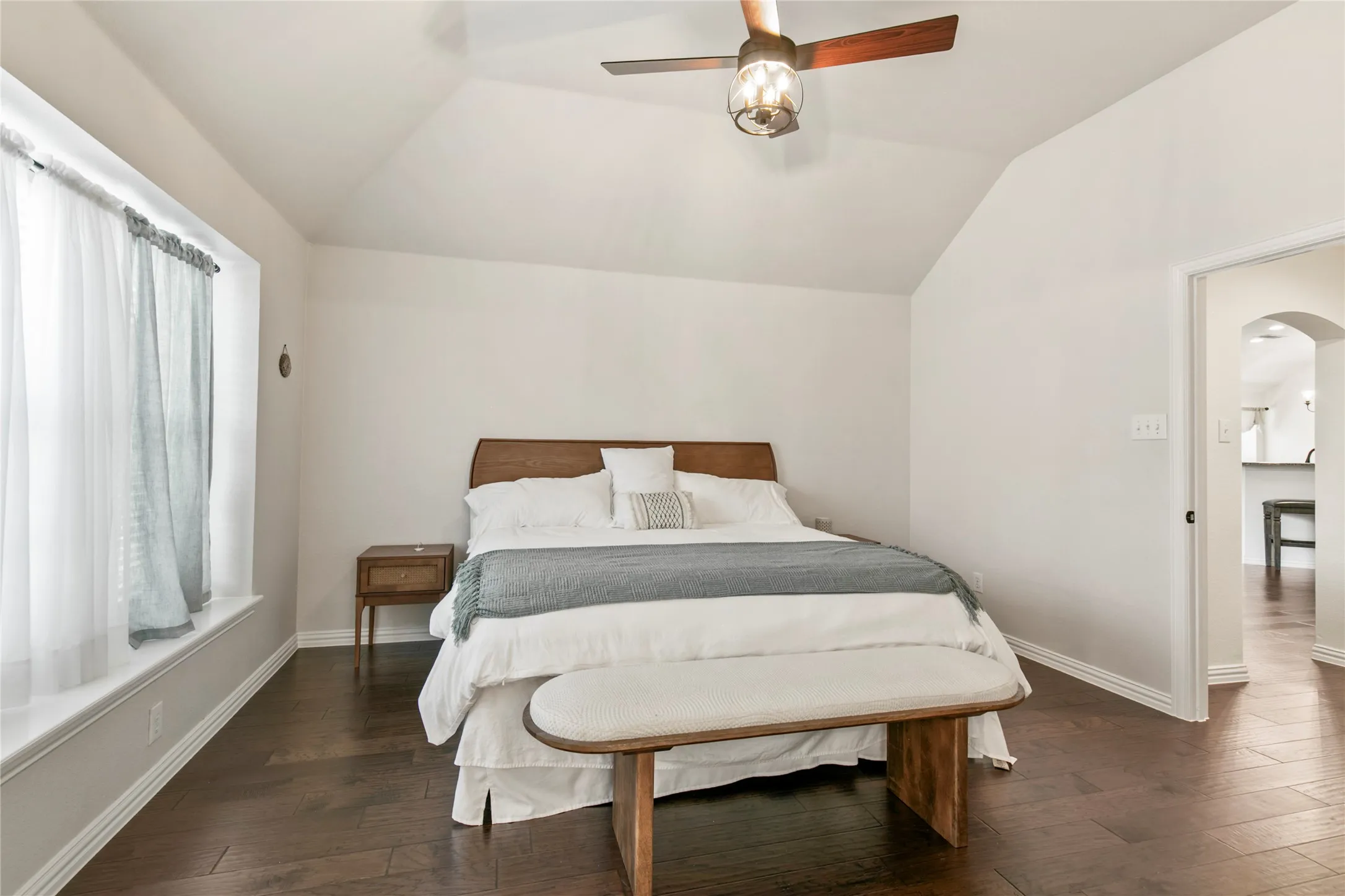 Vaulted ceiling with a wood-finish ceiling fan and integrated lighting