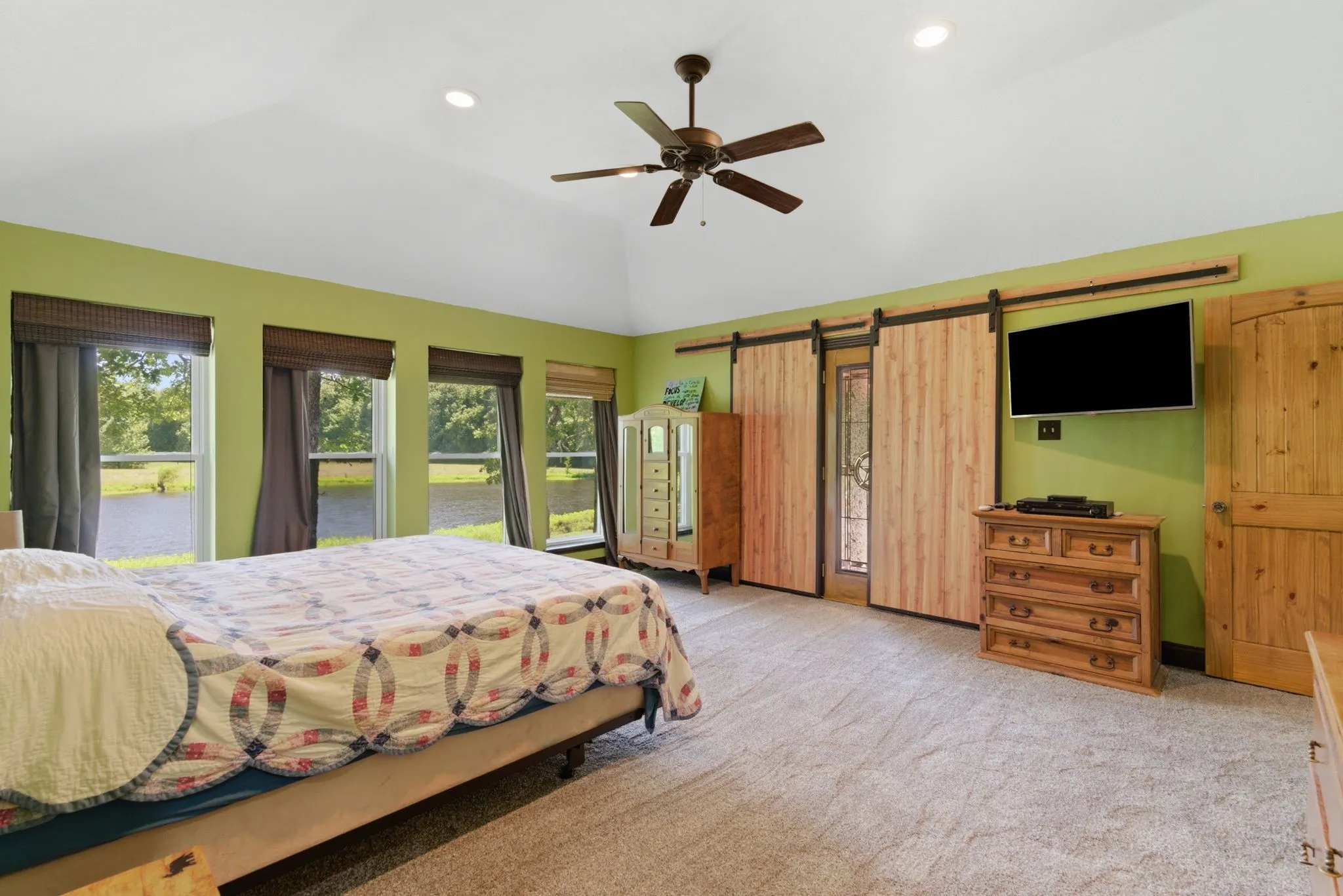 Plenty of natural light in the primary with rustic barn doors covering the entry to the back patio,