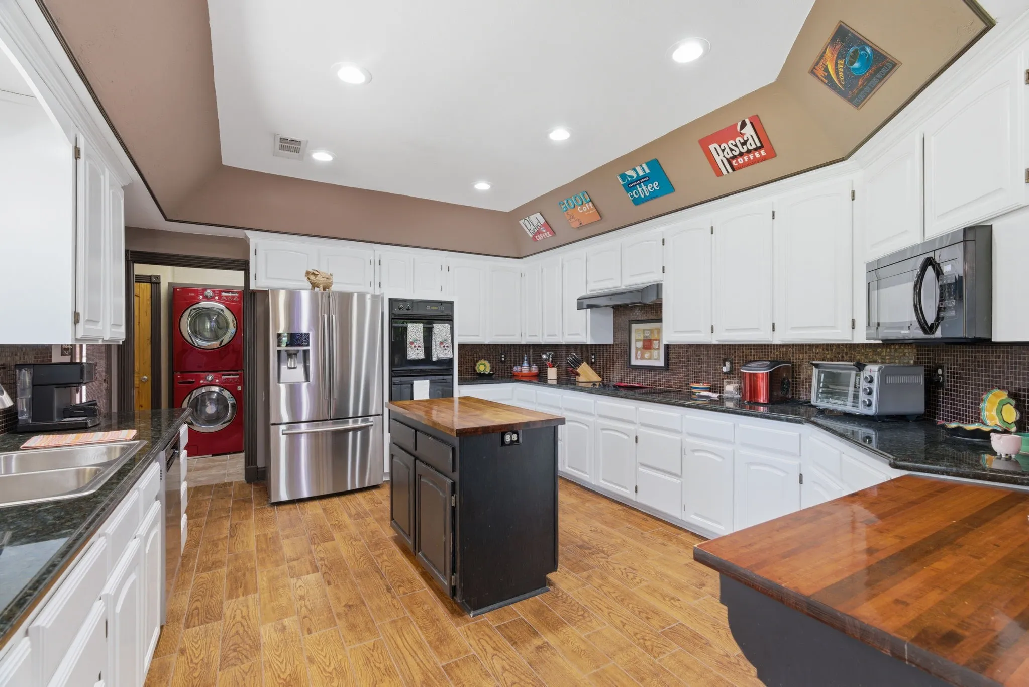 Featuring electric cooktop, double ovens, stainless steel appliances, and freshly painted cabinets.