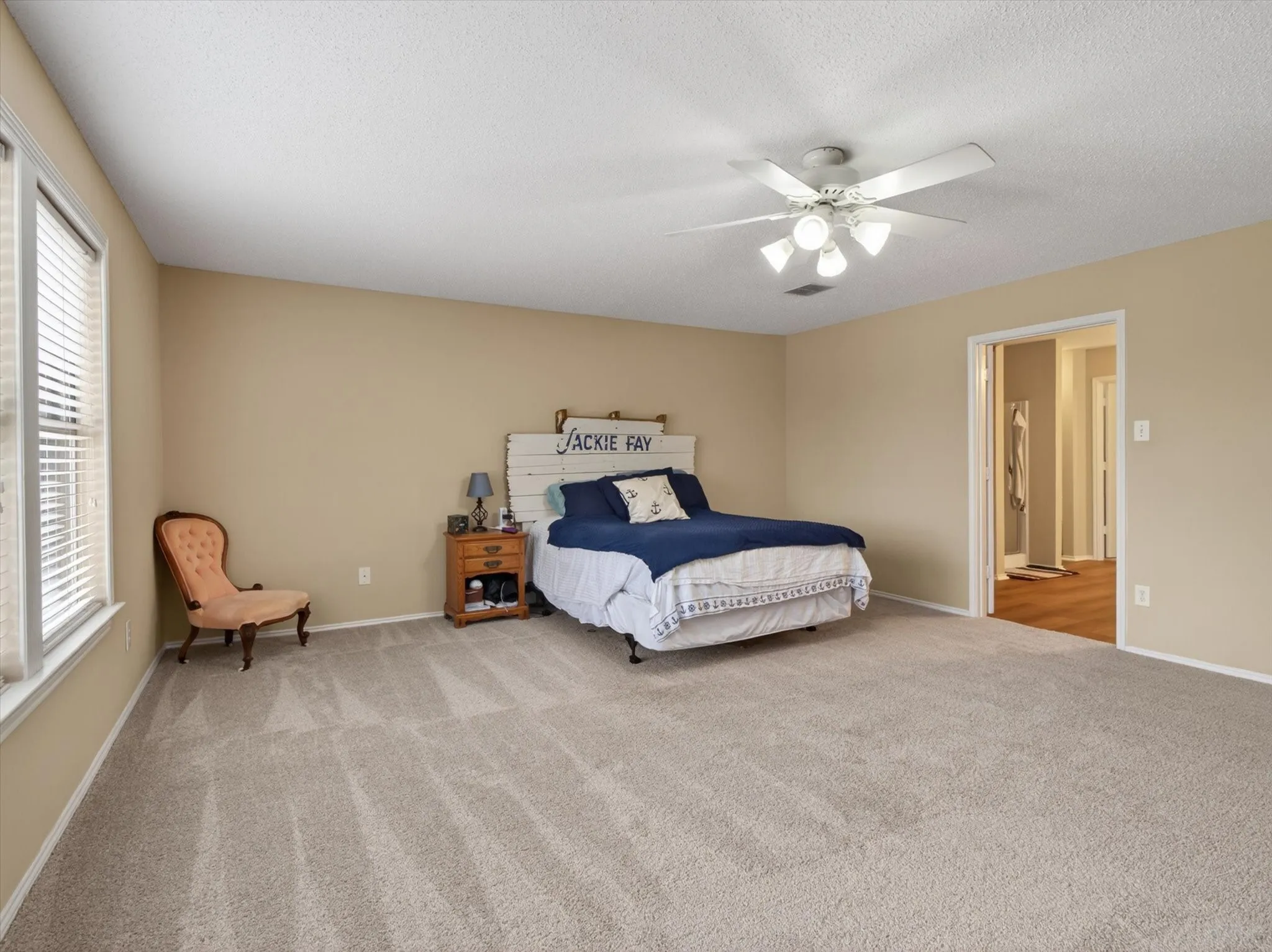 Spacious room featuring neutral carpeting, light beige wall paint, and white trim