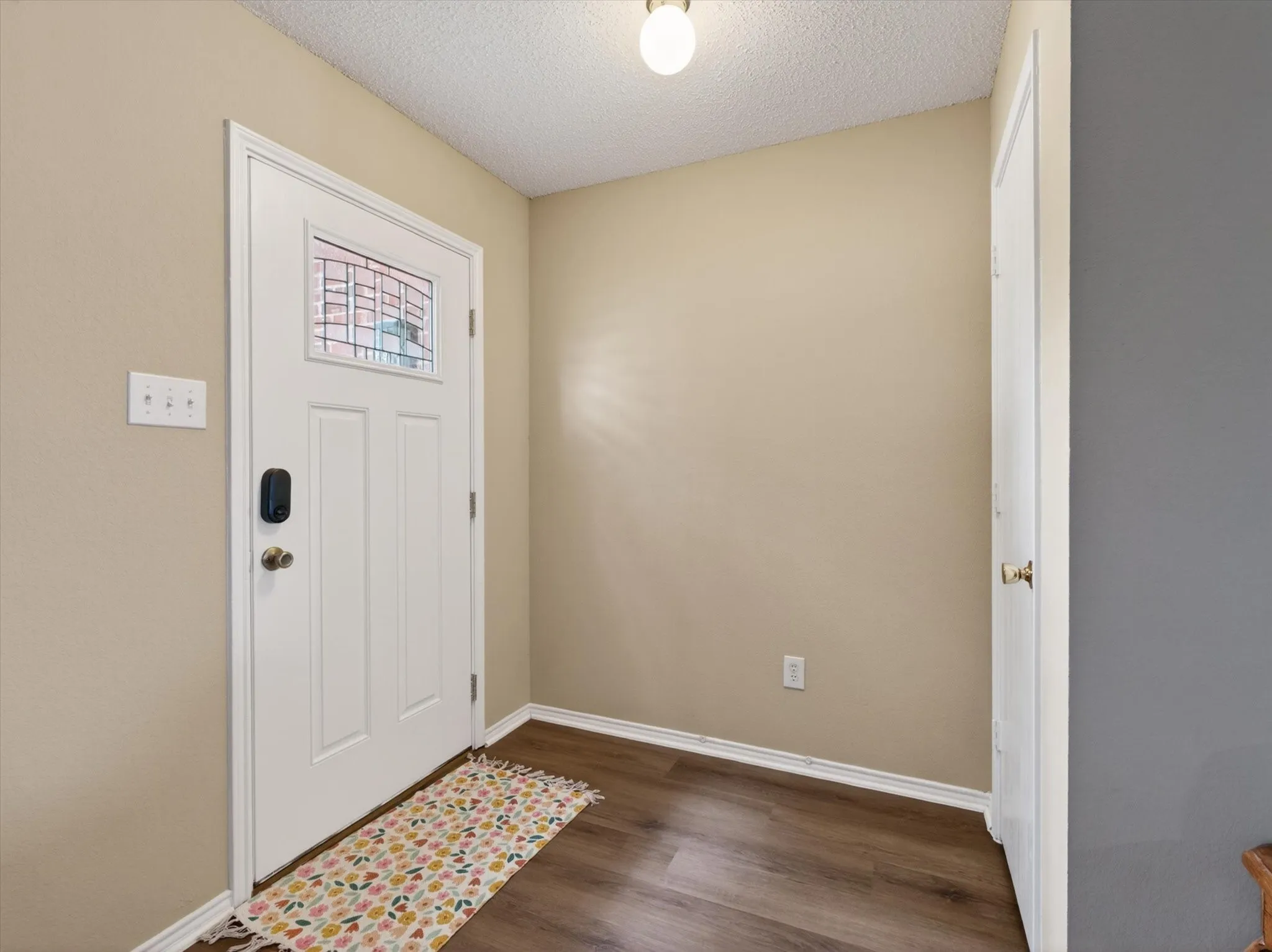 White entry door with decorative glass inserts and smart lock system