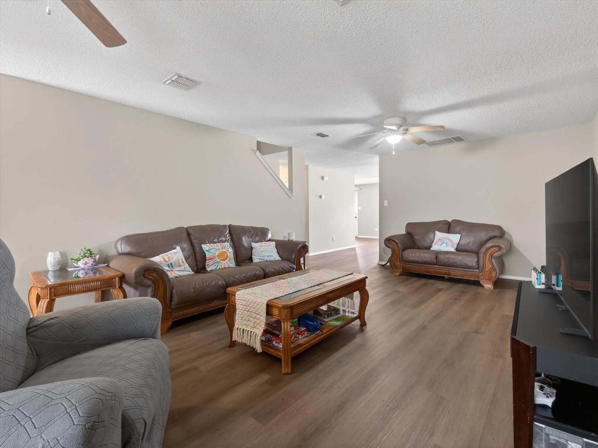 Spacious living area featuring wood-finish flooring, neutral wall tones, and recessed lighting