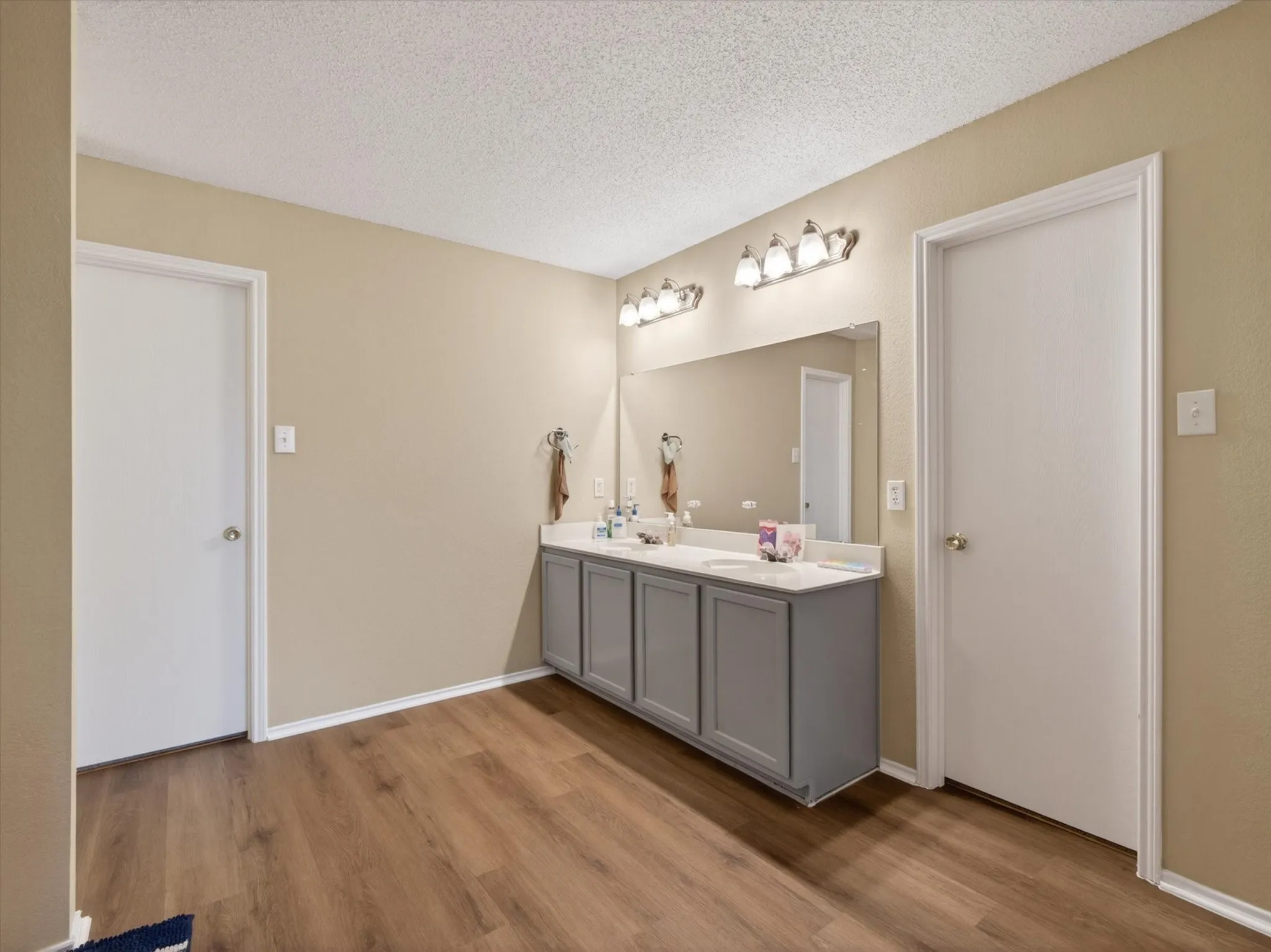 Dual vanity with light gray cabinetry and white countertops