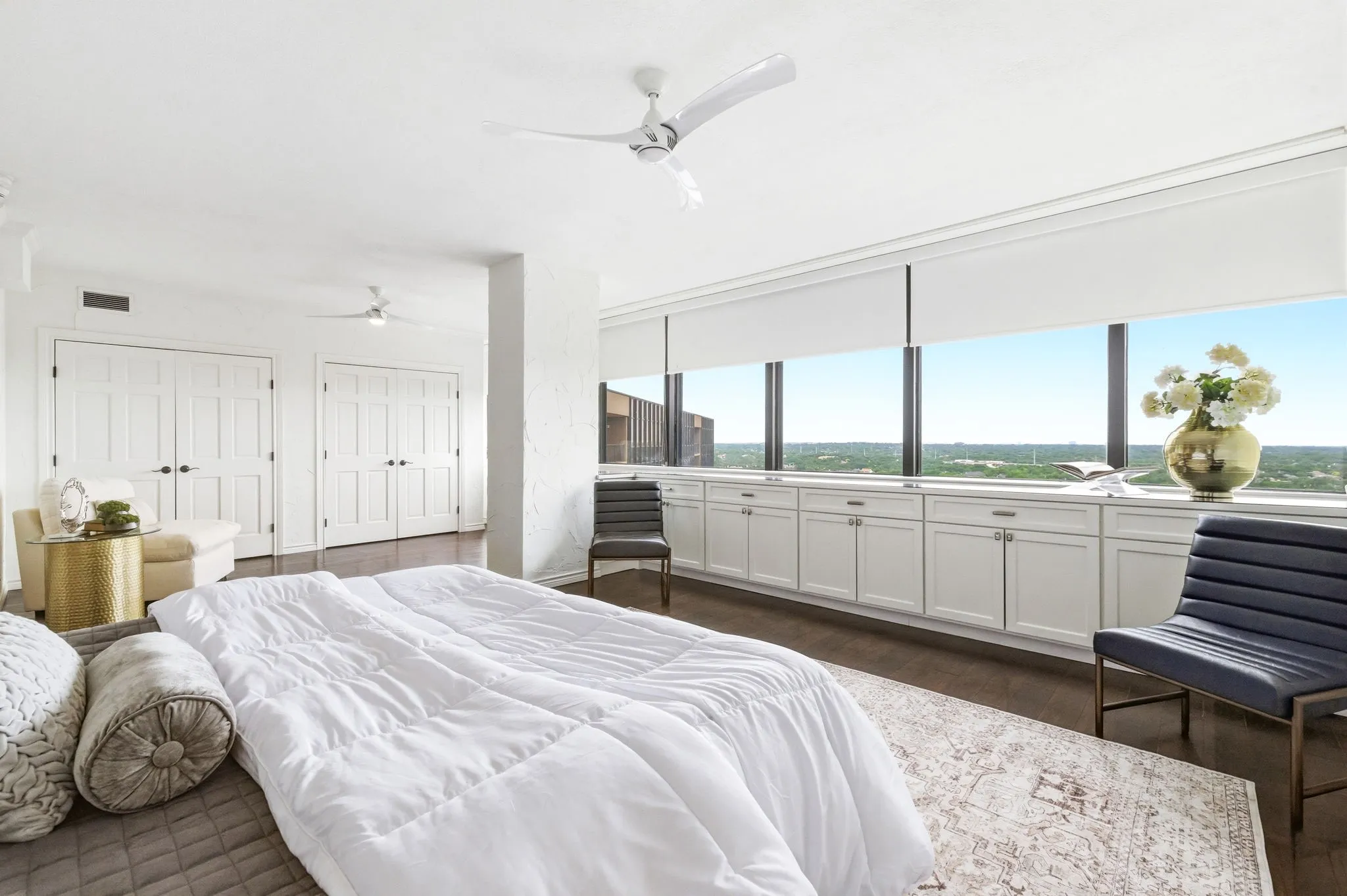 Expansive windows with roller shades offer broad exterior scenery