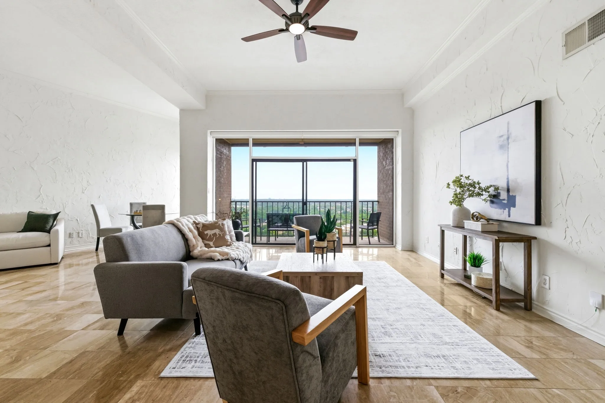 Spacious living area featuring wood-finish flooring, textured walls, and crown molding