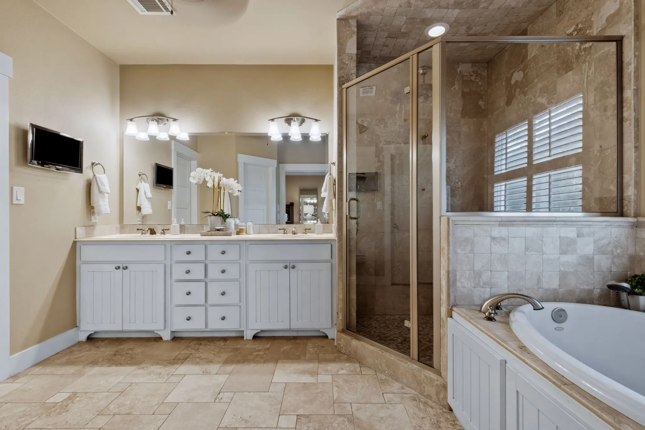 The ensuite showcases a deep soaking tub and walk-in shower.