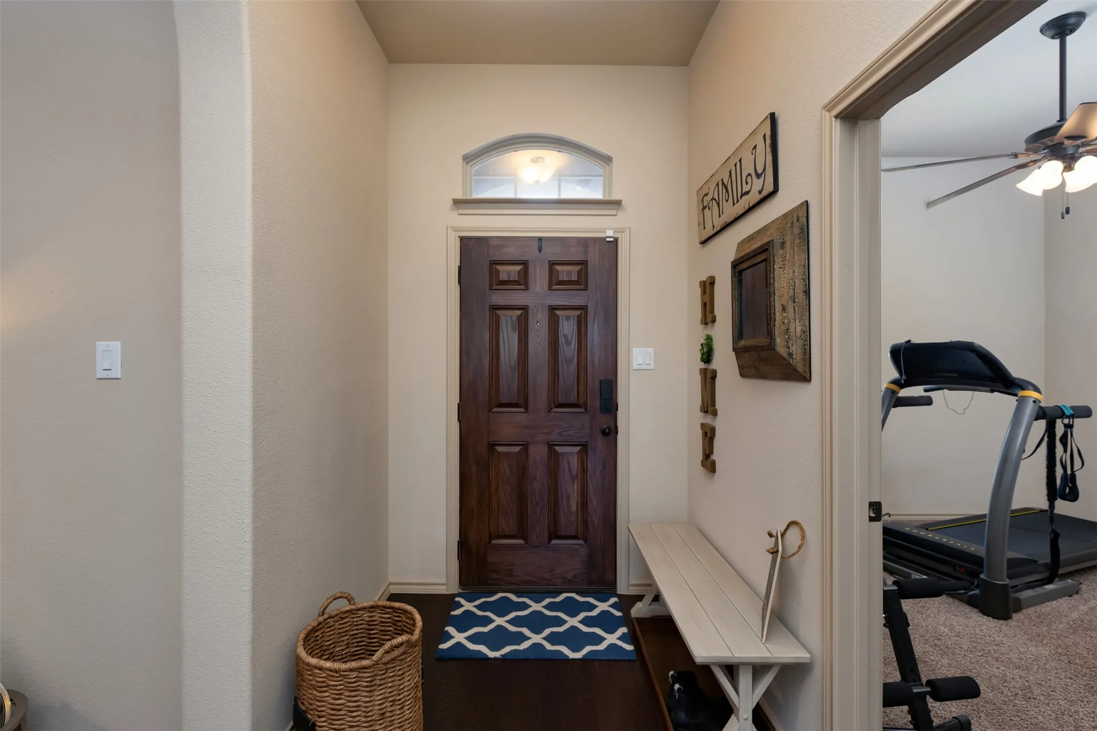 Front entry hallway with a sneak peak into exercise room located in front bedroom to home.